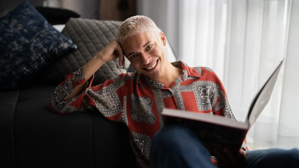 Portrait of a happy young man reading at home