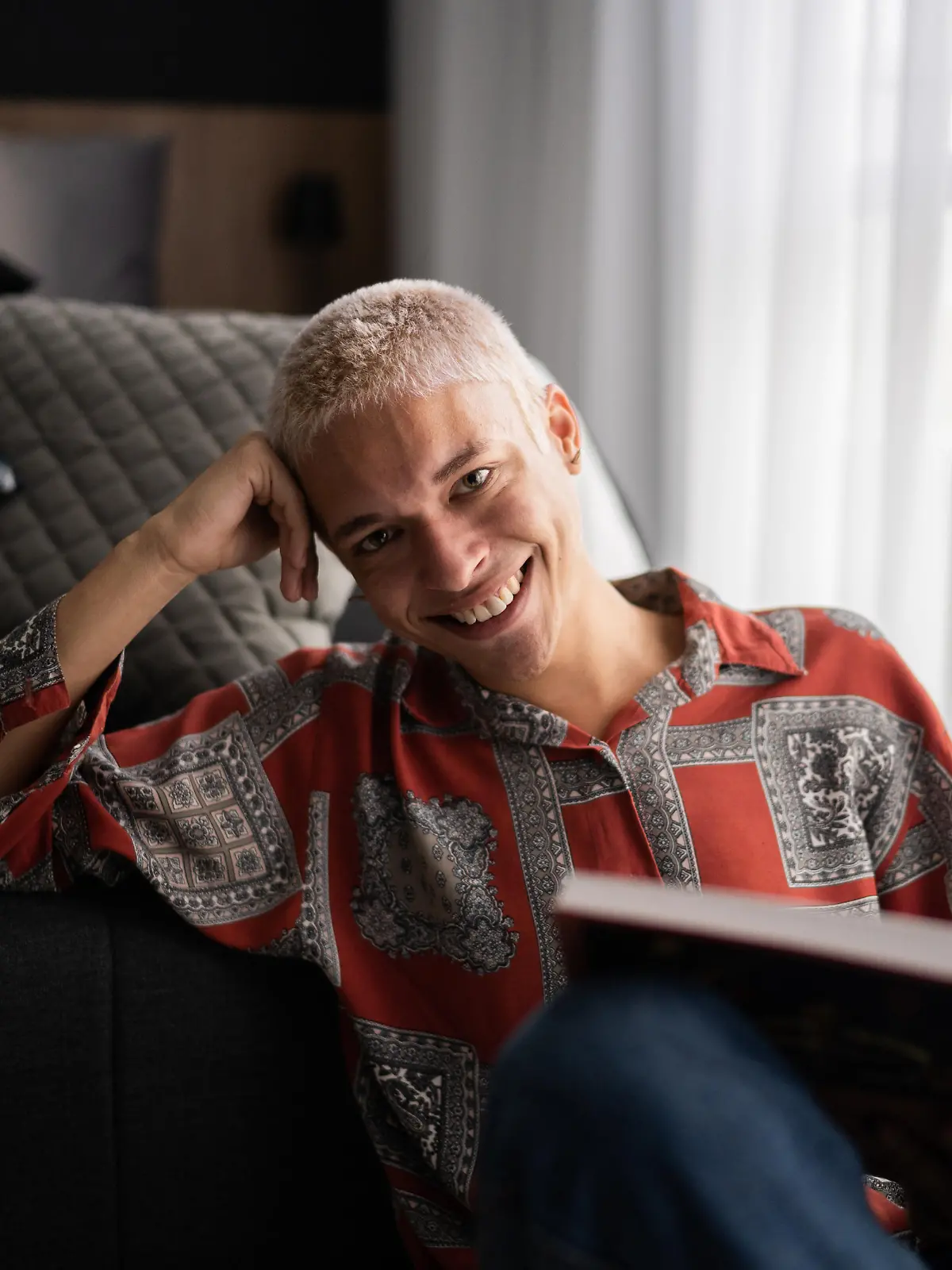 Portrait of a happy young man reading at home