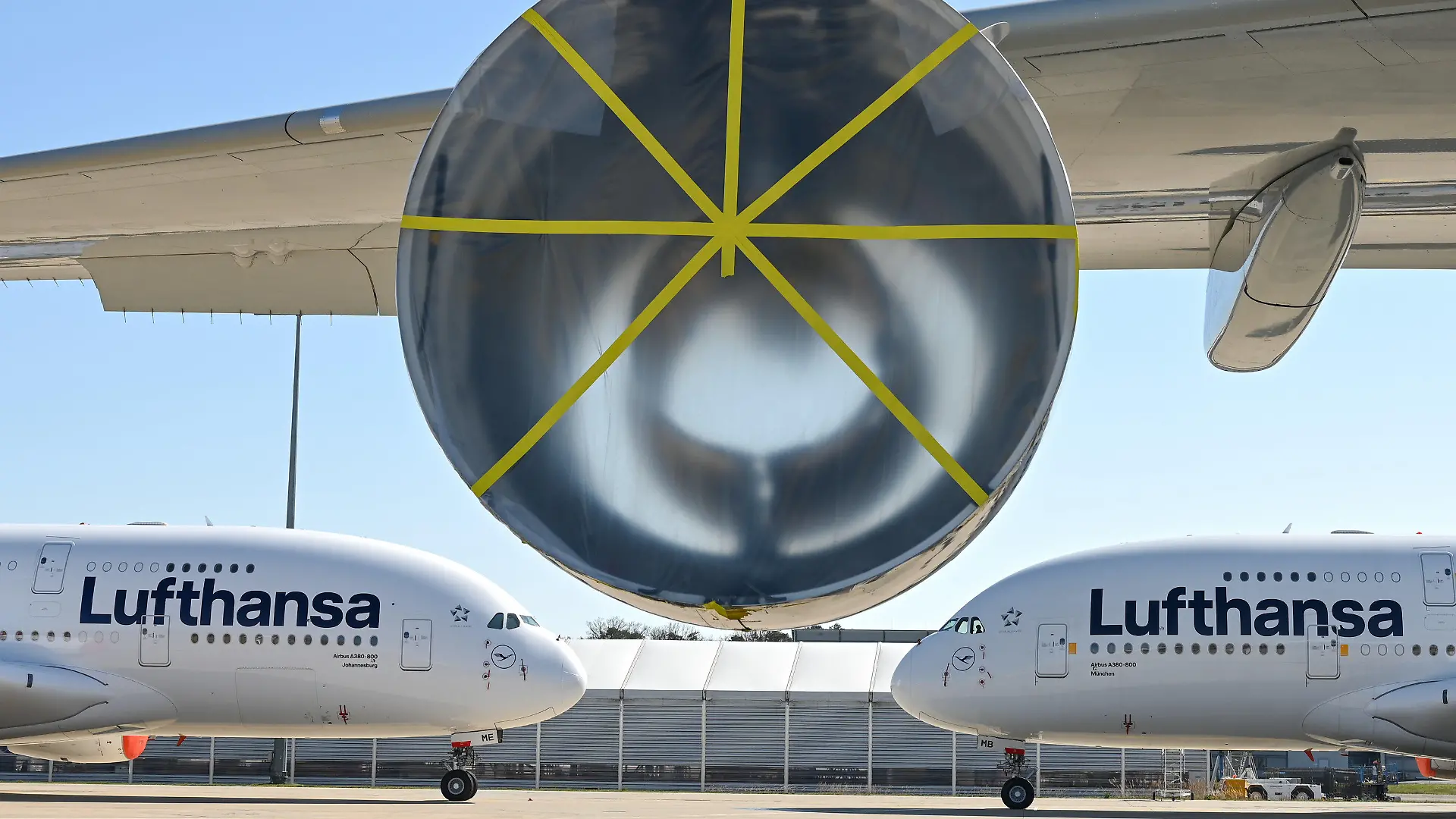 ARCHIV - 23.03.2020, Hessen, Frankfurt/Main: Zwei Airbus A380-800 der Lufthansa sind auf dem Gelände der Lufthansa Technik am Frankfurter Flughafen hinter einem A380 geparkt, an dem ein Triebwerk ausgebaut worden war. Die Lufthansa hatte damals damit begonnen, in der Coronavirus-Krise überflüssige Flugzeuge am Frankfurter Flughafen zur parken. Die Lufthansa muss in der Corona-Krise noch stärker schrumpfen als bislang geplant. Mindestens 150 Flugzeuge der einstmals 760 Jets umfassenden Konzernflotte werden dauerhaft nicht mehr abheben. (Zu dpa "Lufthansa will härter sparen - A 380 werden eingemottet") Foto: Arne Dedert/dpa Pool/dpa +++ dpa-Bildfunk +++
