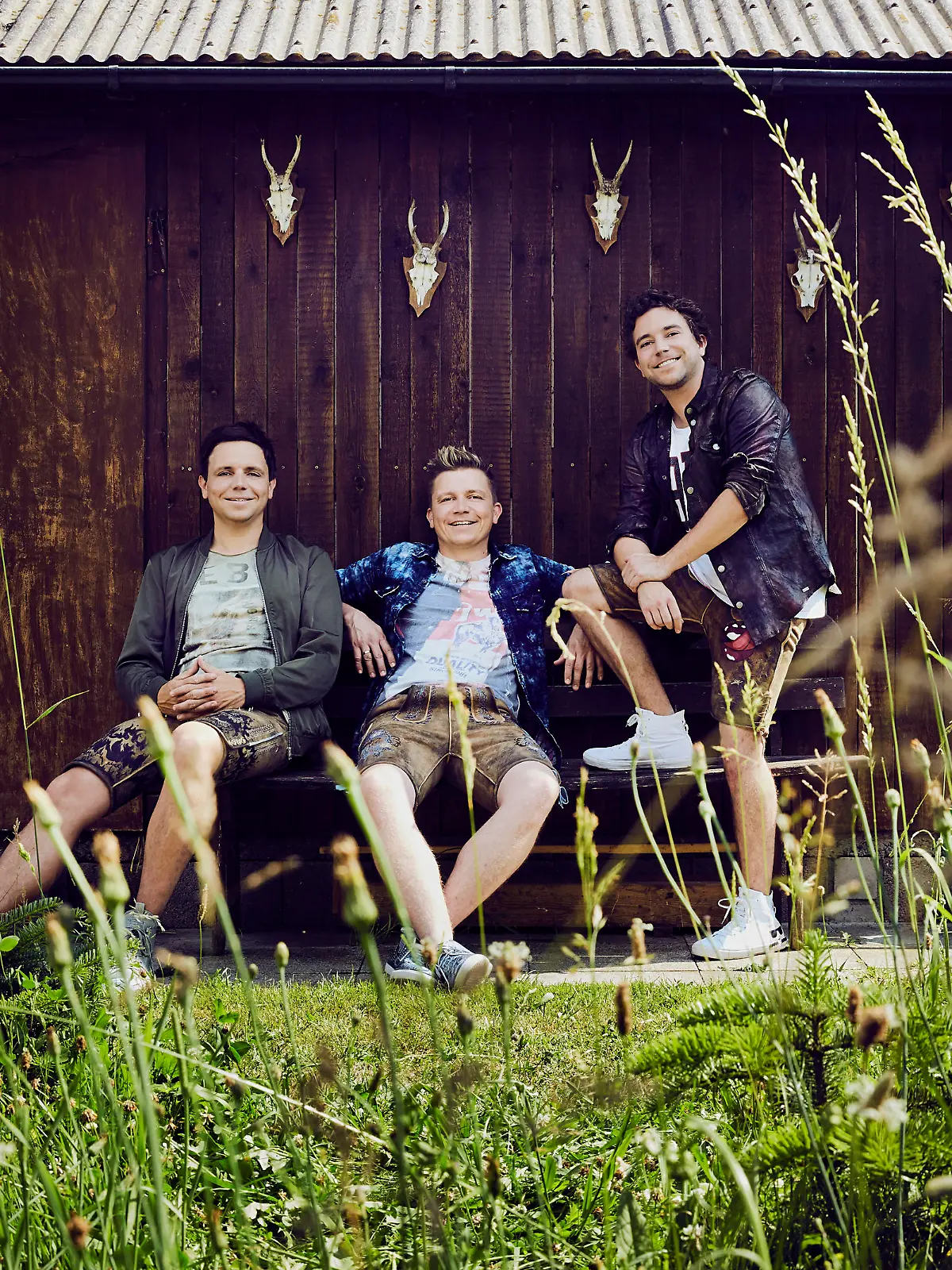 Die Band "Dorfrocker" posiert vor einer Holzwand
