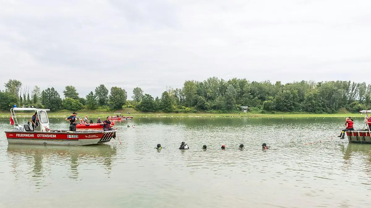 HANDOUT - 21.08.2019, Österreich, Linz/Ottensheim: Taucher und Rettungskräfte auf der Suche nach dem verunglückten Sportler, der nur tot geborgen werden konnte. Bei den Vorbereitungen zur Ruder-WM in Ottensheim ist ein Para-Sportler aus Weißrussland mit seinem Boot auf der Donau umgekippt und untergegangen. Der tödliche Unfall eines behinderten Sportlers aus Weißrussland bei den Vorbereitungen zur Ruder-Weltmeisterschaft in Österreich ist auf ein defektes Sportgerät zurückzuführen. Eine Stabilisationsvorrichtung am Boot sei gebrochen gewesen, teilte die Polizei am Donnerstag (22.08.2019) mit. Foto: Bayer/BFKDO UU/APA/dpa - ACHTUNG: Nur zur redaktionellen Verwendung im Zusammenhang mit der aktuellen Berichterstattung und nur mit vollständiger Nennung des vorstehenden Credits +++ dpa-Bildfunk +++