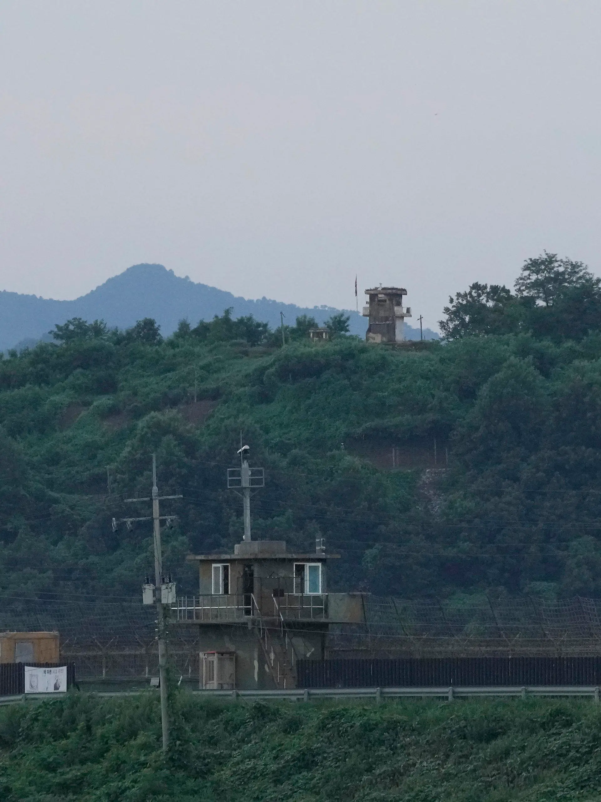 18.07.2023, Südkorea, Paju: Ein nordkoreanischer Wachposten (hinten) und ein südkoreanischer Wachposten (vorne) in der Nähe der Grenze zu Nordkorea. Ein US-Amerikaner hat ohne Erlaubnis die innerkoreanische Grenze von Süd- nach Nordkorea überquert und ist daraufhin festgenommen worden. Foto: Ahn Young-joon/AP/dpa +++ dpa-Bildfunk +++