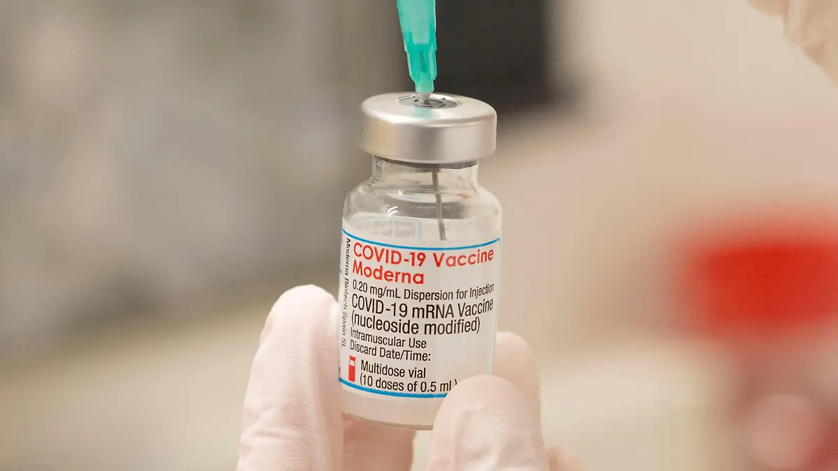 FILE PHOTO: A healthcare worker fills up a syringe with a dose of Moderna's COVID-19 vaccine for a booster shot at the vaccination reference center at the Epidemiology, Biostatistics and Prevention Institute (EBPI) in Zurich, Switzerland November 17, 2021. REUTERS/Arnd Wiegmann/File Photo