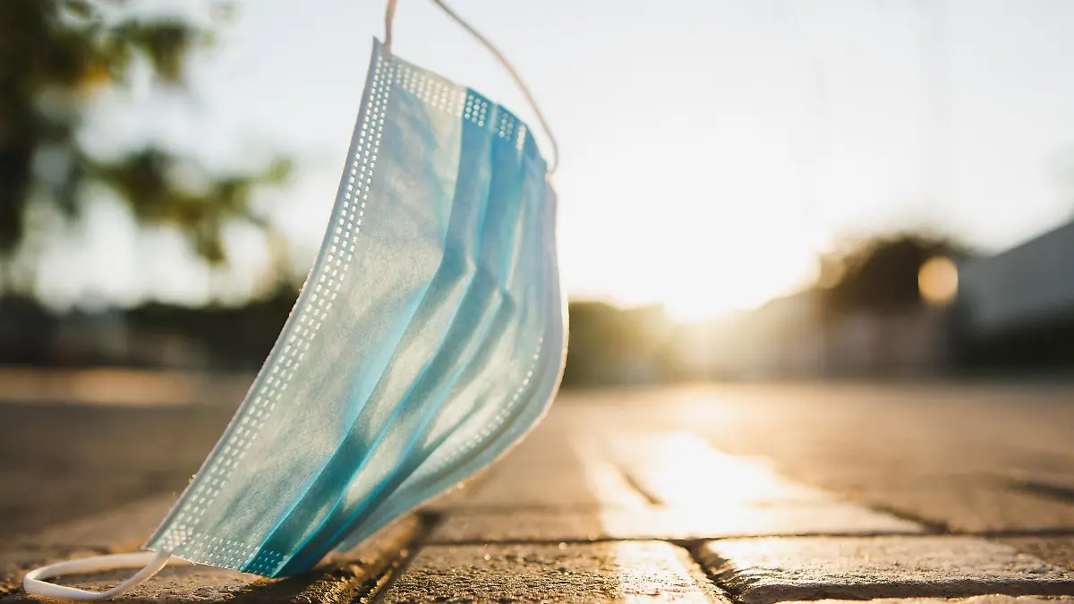 Coronavirus face protection mask used and discarded on the street that harms the environment