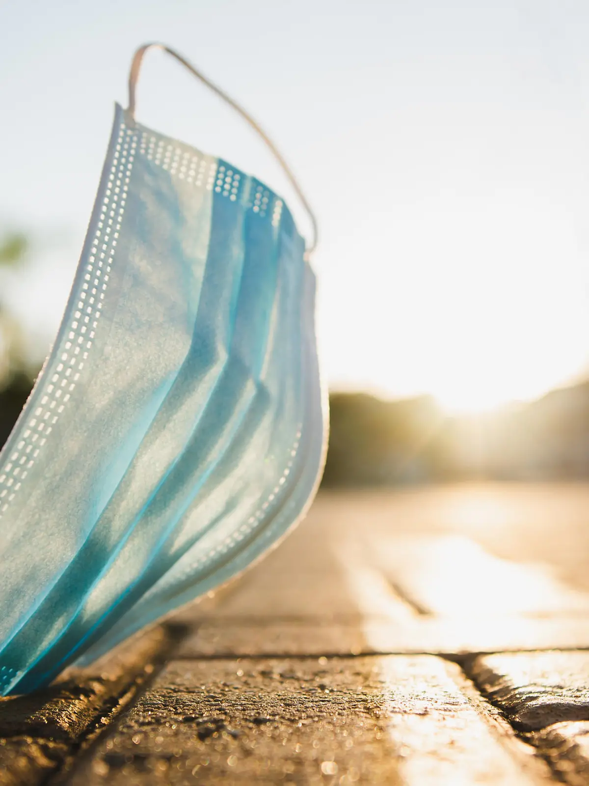 Coronavirus face protection mask used and discarded on the street that harms the environment