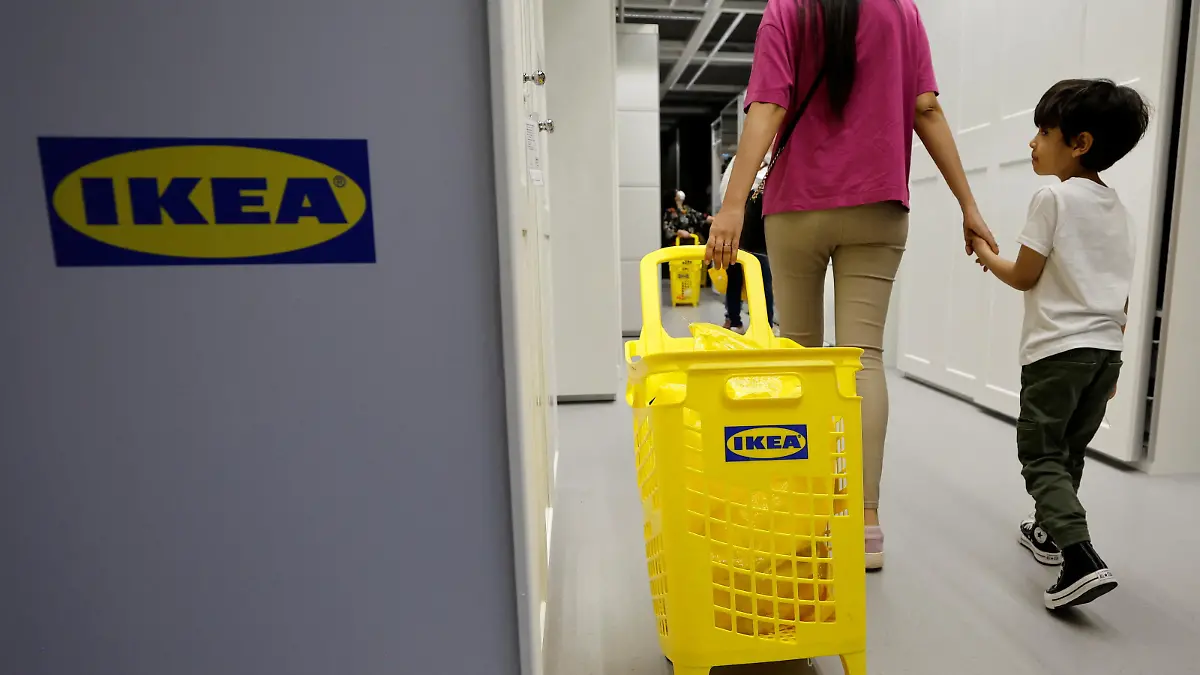 A woman holds a child's hand as she walks with a shopping trolley inside an IKEA store in Nice, France, May 11, 2022. REUTERS/Eric Gaillard