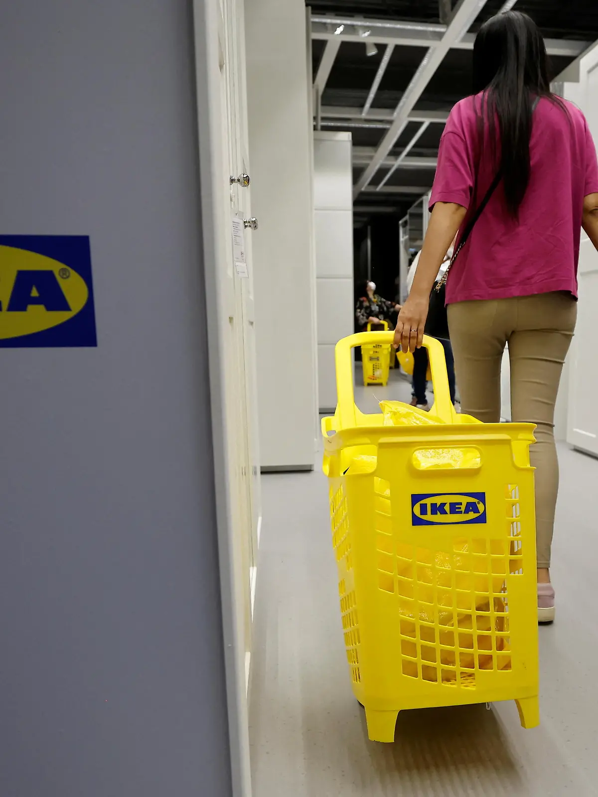 A woman holds a child's hand as she walks with a shopping trolley inside an IKEA store in Nice, France, May 11, 2022.  REUTERS/Eric Gaillard
