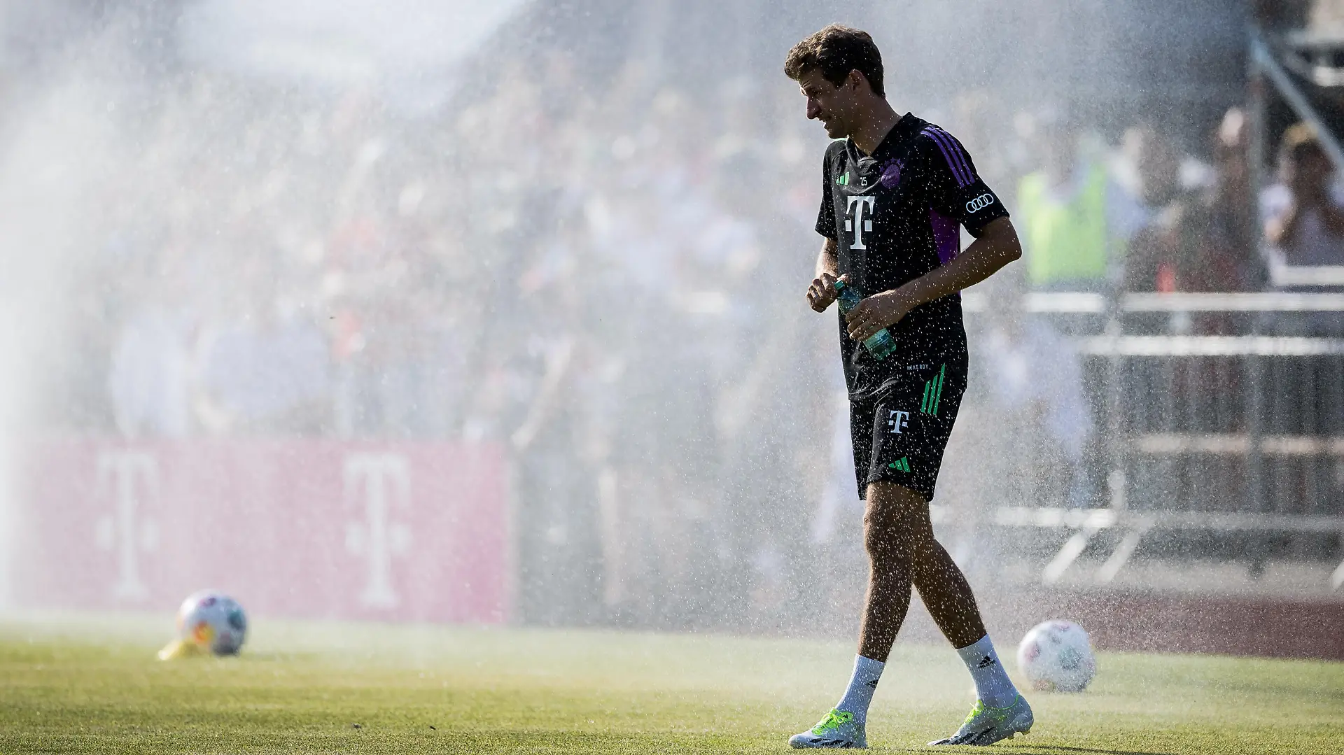 Thomas Mueller (FC Bayern Muenchen, #25) laeuft lachend durch den Rasensprenger Oeffentliches Training FC Bayern Muenchen; Sportplatz Rottach-Egern, 15.07.2023