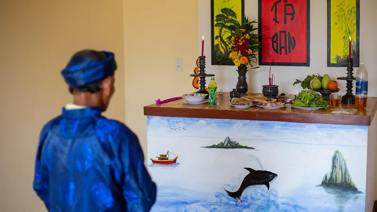 PRODUKTION - 02.03.2021, Vietnam, Tam Hai: Ein Gläubiger betet vor einem Altar mit dem Bild eines Wals während des Walanbetungsfestes in Tam Hai.   (zu dpa: «Schutz aus den Tiefen des Ozeans: Die Wal-Götter von Vietnam») Foto: Chris Humphrey/dpa +++ dpa-Bildfunk +++