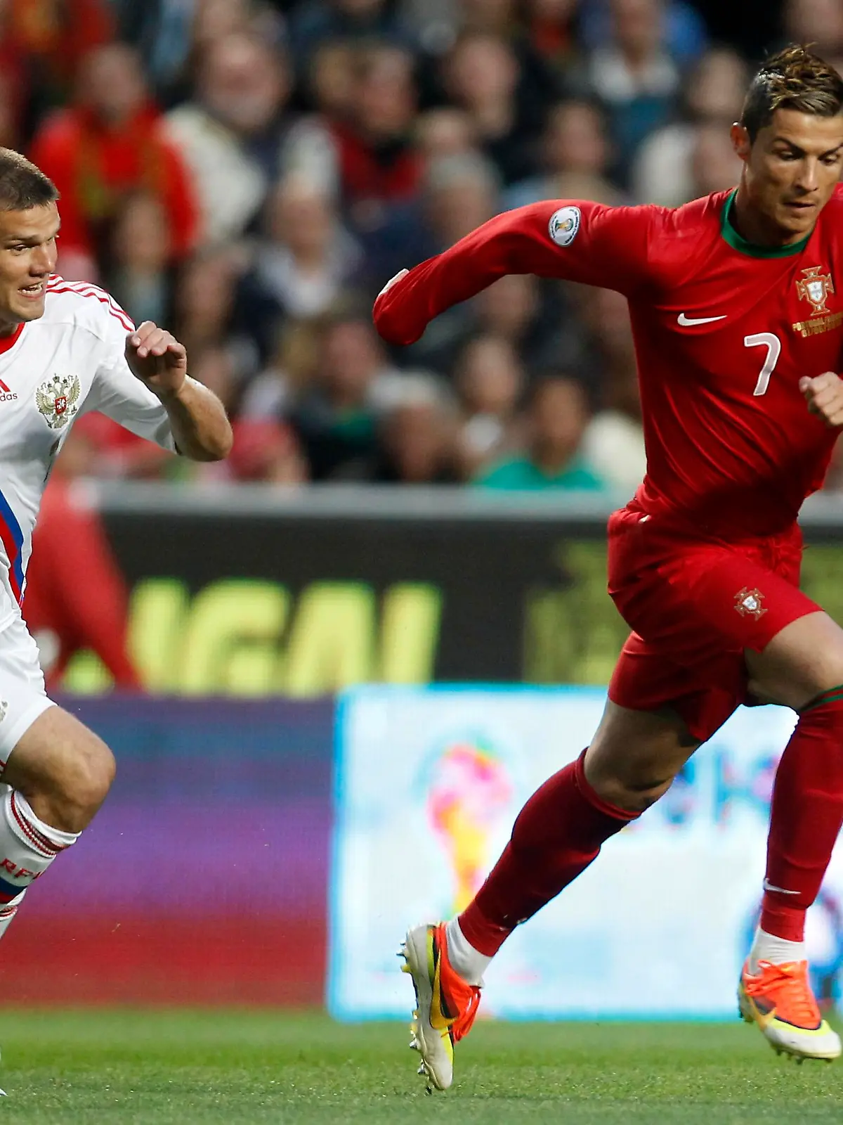 Portugal's Cristiano Ronaldo (R) fights for the ball with Russia's Igor Denisov during their 2014 World Cup qualifying soccer match at Luz stadium in Lisbon June 7, 2013. REUTERS/Jose Manuel Ribeiro (PORTUGAL - Tags: SPORT SOCCER)