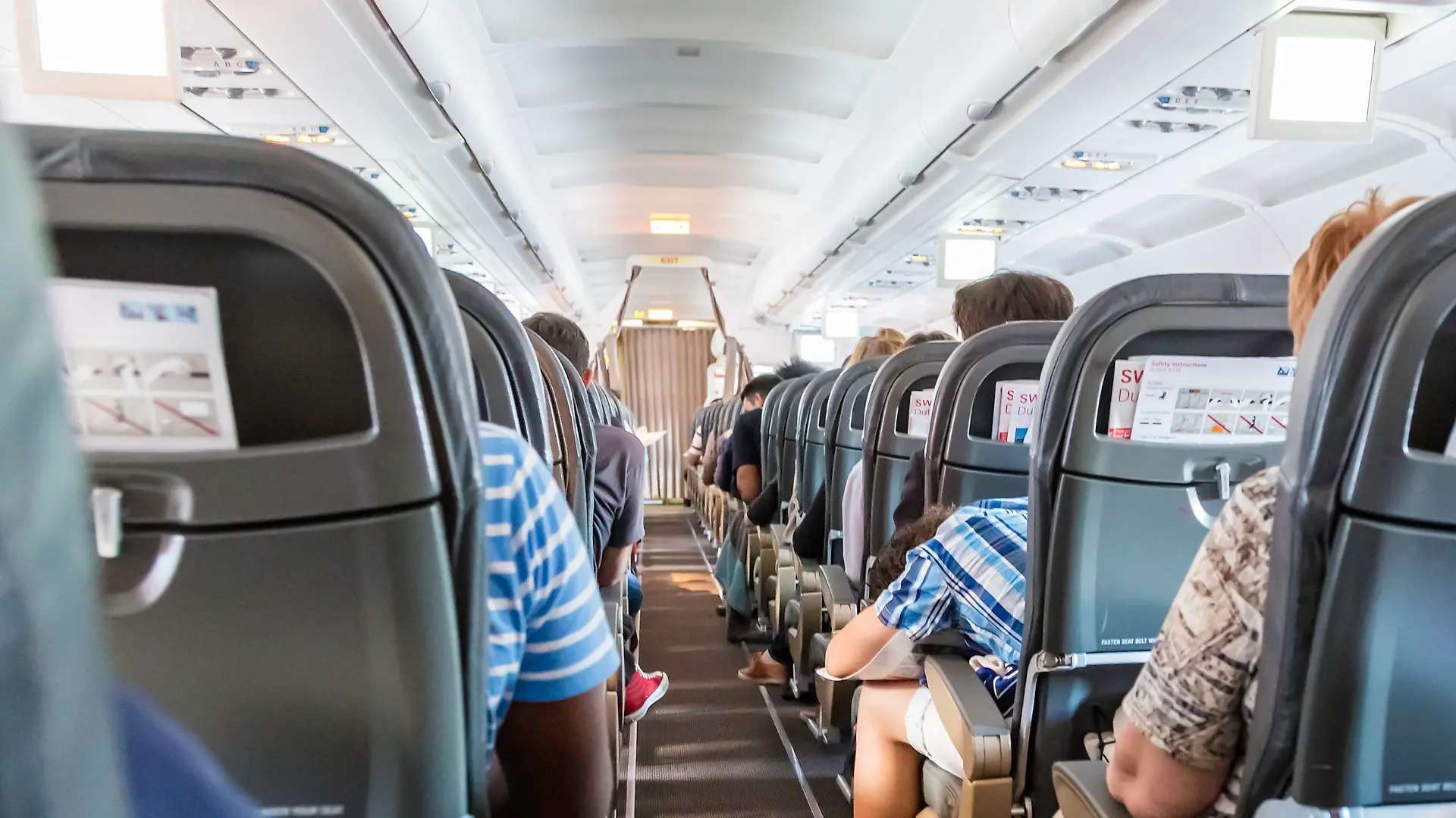 Geneve, Switzerland - August, 22nd 2014: Anxious passengers seen from behind inside a Swiss airliner taking off from Geneve airport. An Airbus 319 jet, about to embark.