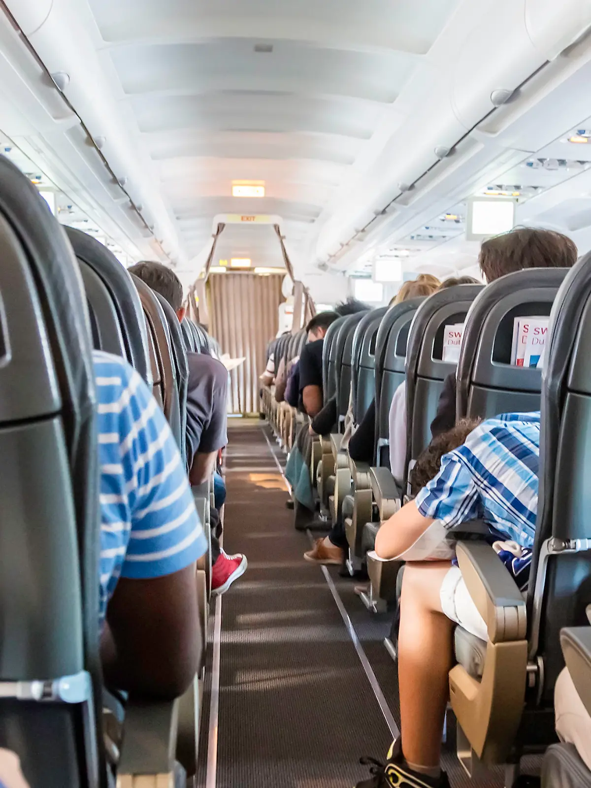 Geneve, Switzerland - August, 22nd 2014: Anxious passengers seen from behind inside a Swiss airliner taking off from Geneve airport. An Airbus 319 jet, about to embark.