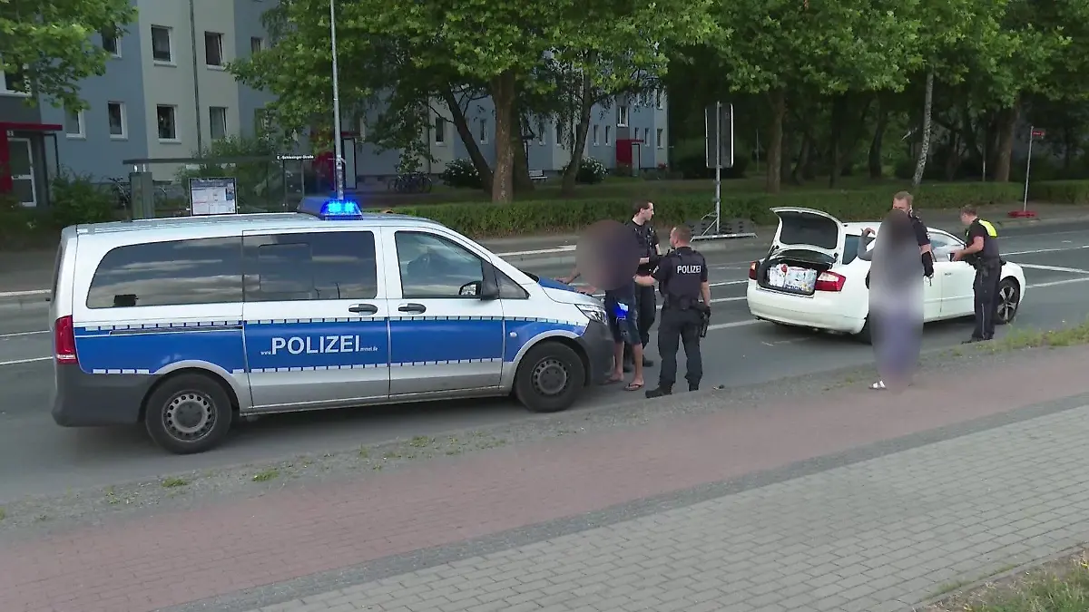 Festnahme: Einer der Tatverdächtigen wird von der Polizei festgehalten, während die mutmaßlich attackierte Frau eine Aussage macht.