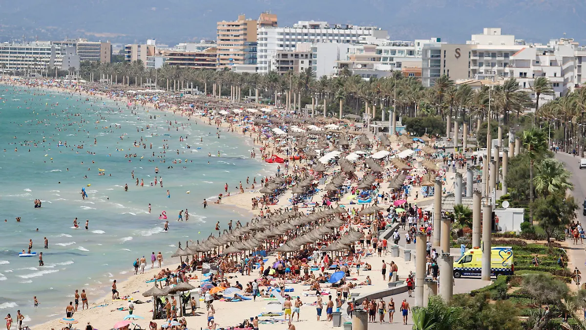 ARCHIV - 12.08.2018, Spanien, Palma: Ein Krankenwagen fährt auf den Strand von El Arenal, wo sich zahlreiche Touristen sonnen und baden. Der Strand ist eines der Hauptziele für deutsche und niederländische Touristen während der Sommersaison auf der Balearen-Insel Mallorca. Der heiße Sommer hat die Reiselust der Bundesbürger in diesem Jahr nicht gedämpft - im Gegenteil. (zu dpa «Tourismusverband BTW: Bundesbürger zum Jahreswechsel in Reiselaune») Foto: Clara Margais/dpa +++ dpa-Bildfunk +++