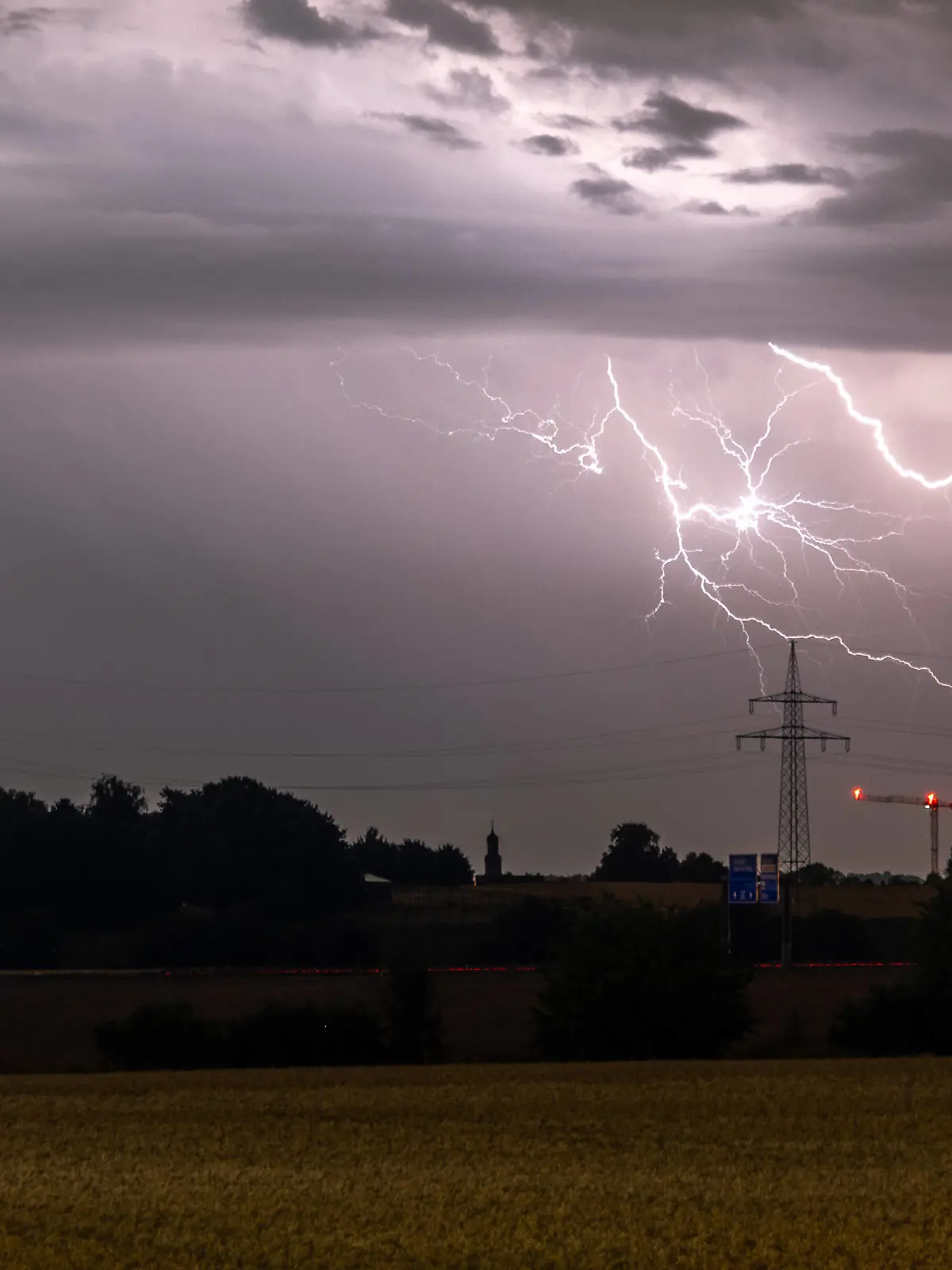 Gewitter in Hessen Blitze eines Gewitters sind am späten Abend am Himmel hinter einer Stromleitung zu sehen., Bad Homburg Hessen Deutschland *** Thunderstorm in Hesse Lightning of a thunderstorm is seen in the late evening in the sky behind a power line , Bad Homburg Hesse Germany