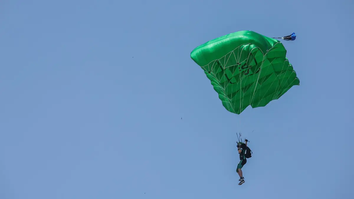 Ein Fallschirmspringer fliegt langsam auf die Erde.