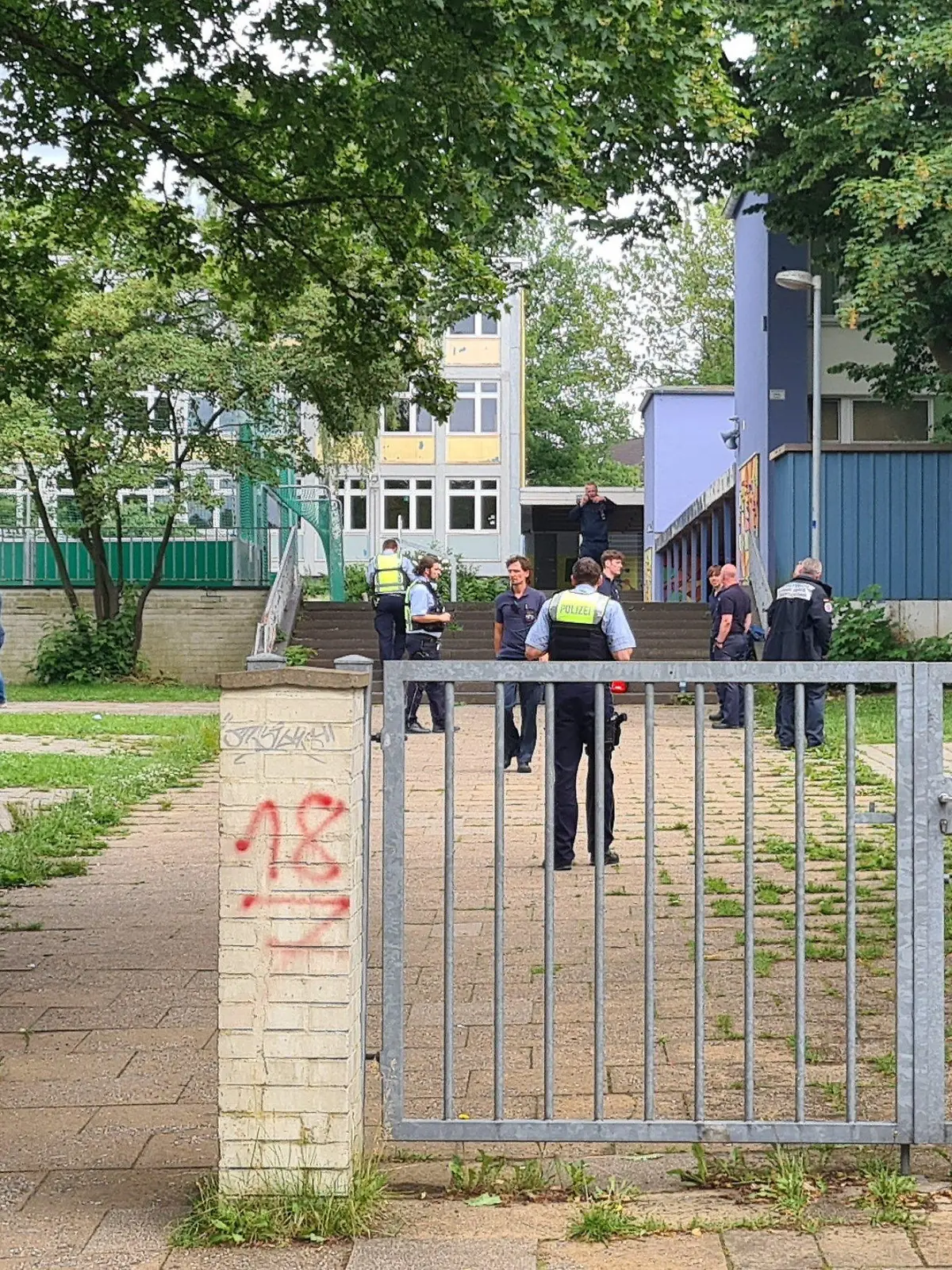 10.06.2022, Nordrhein-Westfalen, Essen: Einsatzkräfte stehen im Eingangsbereich einer Schule. An einer Essener Realschule haben Schüler aus einer Flasche eine unbekannte Flüssigkeit getrunken und danach massive gesundheitliche Probleme bekommen. Fünf Schüler seien in Krankenhäuser gebracht worden, teilte ein Feuerwehrsprecher mit. Darunter seien vier Schüler schwerverletzt, zwei seien bewusstlos. (zu dpa "Schüler tranken unbekannte Flüssigkeit - vier Schwerverletzte") Foto: Markus Gayk/dpa +++ dpa-Bildfunk +++