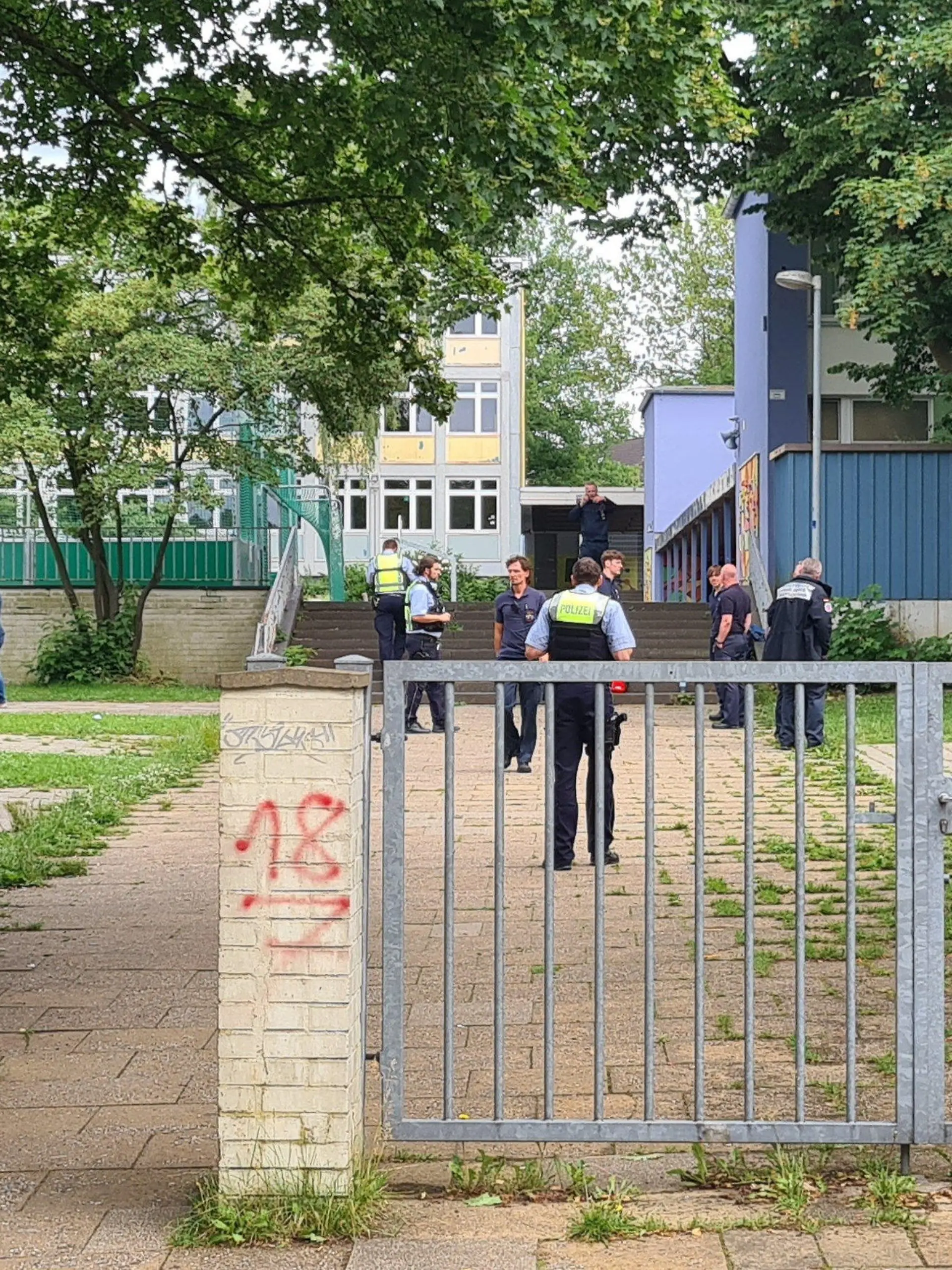 10.06.2022, Nordrhein-Westfalen, Essen: Einsatzkräfte stehen im Eingangsbereich einer Schule. An einer Essener Realschule haben Schüler aus einer Flasche eine unbekannte Flüssigkeit getrunken und danach massive gesundheitliche Probleme bekommen. Fünf Schüler seien in Krankenhäuser gebracht worden, teilte ein Feuerwehrsprecher mit. Darunter seien vier Schüler schwerverletzt, zwei seien bewusstlos. (zu dpa "Schüler tranken unbekannte Flüssigkeit - vier Schwerverletzte") Foto: Markus Gayk/dpa +++ dpa-Bildfunk +++