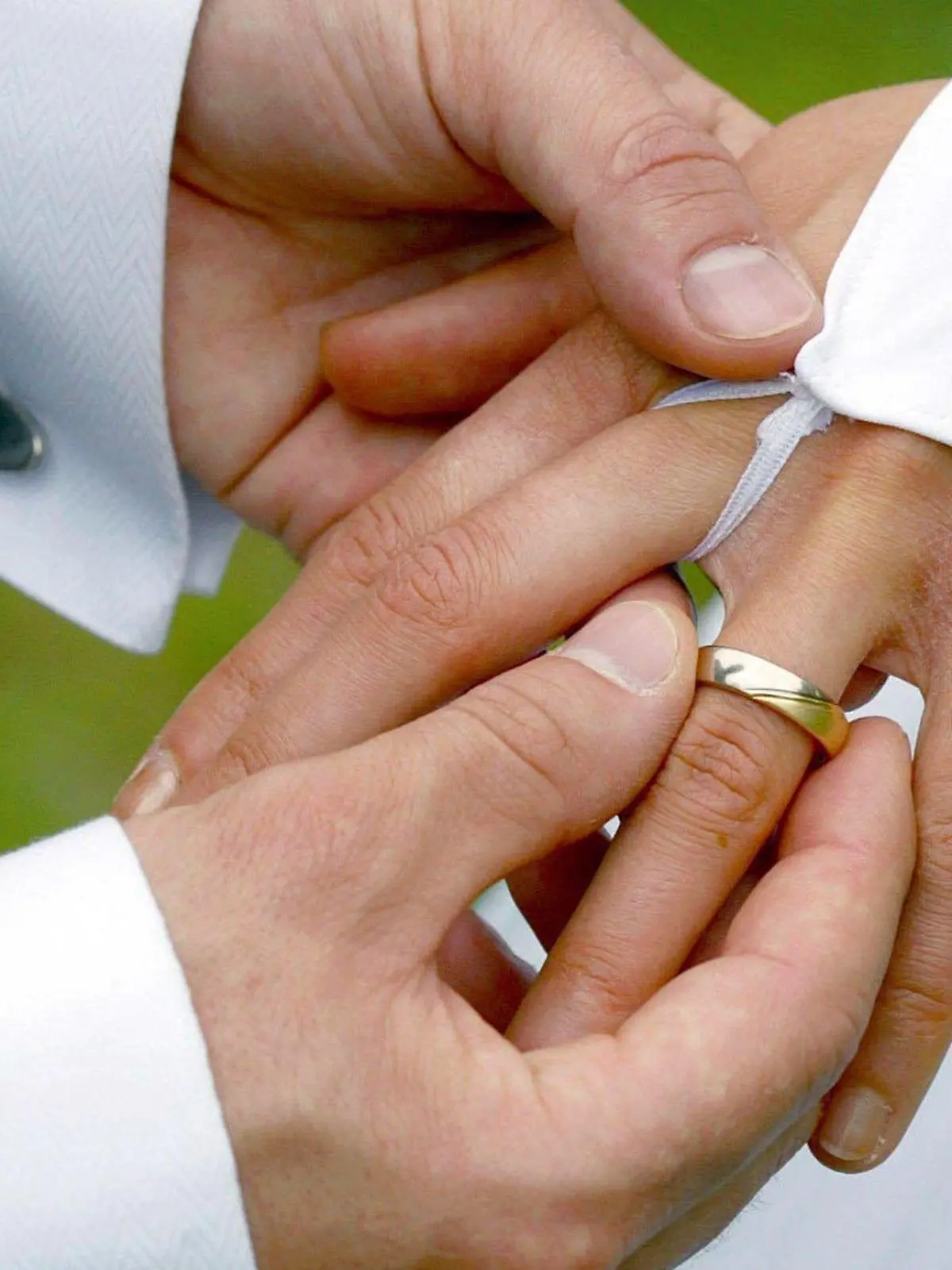 ARCHIV - 26.04.2003, Sachsen-Anhalt, Magdeburg: Bei der Trauung streift der Bräutigam der Braut einen Ehering über den Ringfinger. Heiratstermine an Schnapszahltagen sind beliebt. (zu dpa «Heiraten am Schnapszahldatum - Standesämter haben gut zu tun») Foto: Andreas Lander/zb/dpa +++ dpa-Bildfunk +++