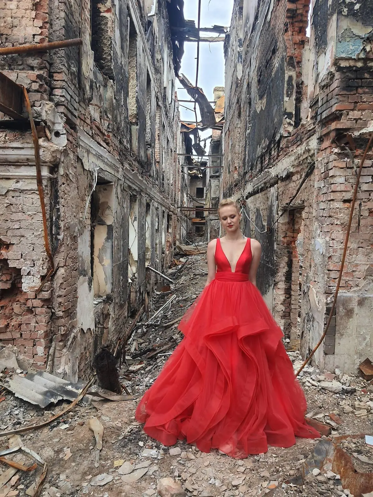 Absolventin Valerie in Charkiw in ihrem Abschlusskleid auf den Trümmern ihrer zerstörten Schule.