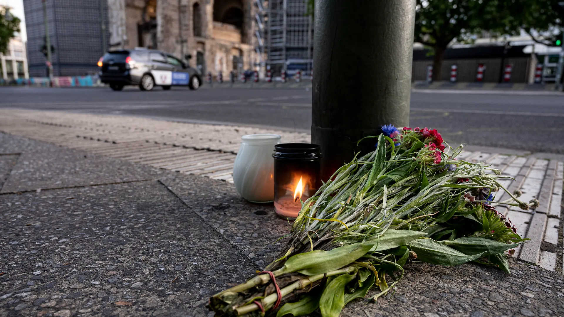dpatopbilder - 09.06.2022, Berlin: Kerzen und ein Blumenstrauß liegen auf dem Bürgersteig an der Tauentzienstraße. Am Vortag war ein 29-jähriger hier mit seinem Auto in der Nähe der Berliner Gedächtniskirche in eine Schülergruppe aus Hessen gefahren, deren Lehrerin ums Leben kam. Foto: Fabian Sommer/dpa +++ dpa-Bildfunk +++