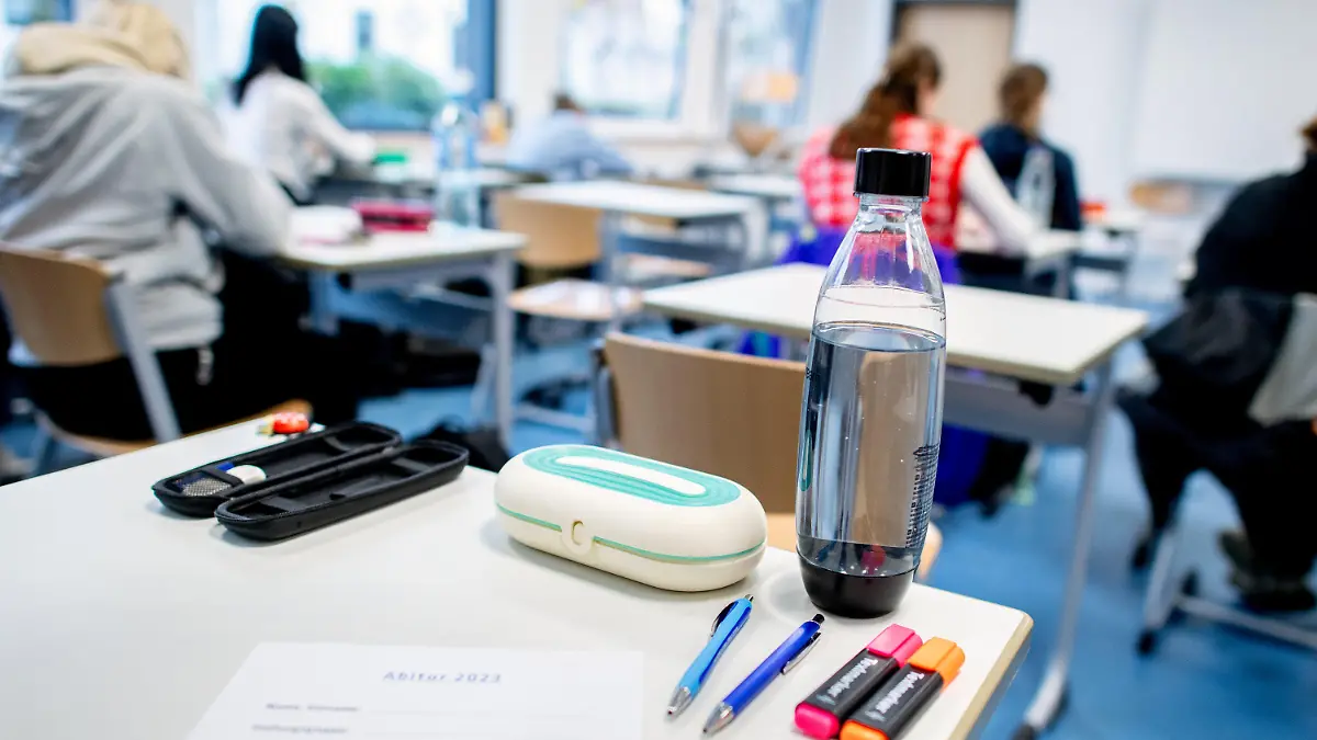 17.04.2023, Niedersachsen, Oldenburg: Mehrere Stifte liegen und eine Wasserflasche steht vor Beginn der schriftlichen Abiturprüfungen im Fach Geschichte auf einem Tisch in der Graf-Anton-Günther-Schule (GAG). In Niedersachsen beginnen die Abschlussprüfungen für den Abiturjahrgang 2023. Bis zum 09.05.2023 werden die Klausuren in unterschiedlichen Fächern geschrieben. Foto: Hauke-Christian Dittrich/dpa +++ dpa-Bildfunk +++