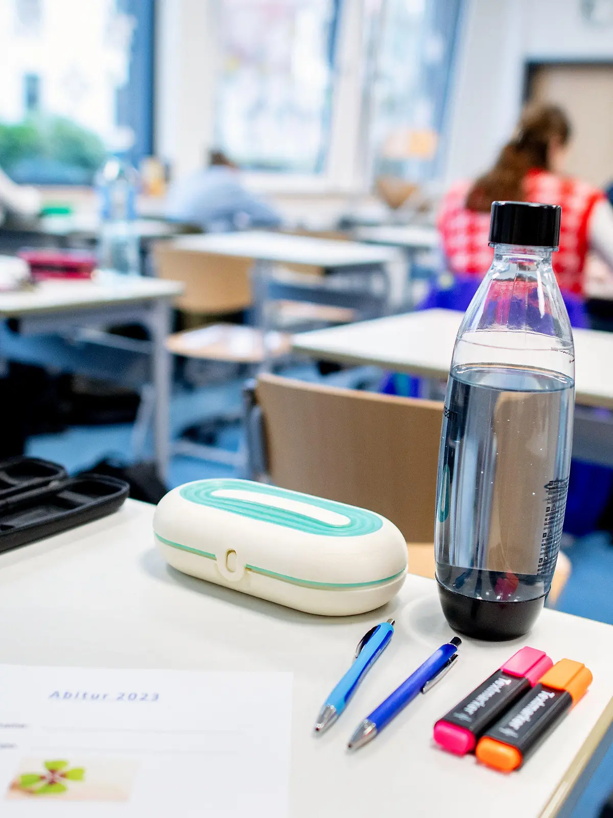 17.04.2023, Niedersachsen, Oldenburg: Mehrere Stifte liegen und eine Wasserflasche steht vor Beginn der schriftlichen Abiturprüfungen im Fach Geschichte auf einem Tisch in der Graf-Anton-Günther-Schule (GAG). In Niedersachsen beginnen die Abschlussprüfungen für den Abiturjahrgang 2023. Bis zum 09.05.2023 werden die Klausuren in unterschiedlichen Fächern geschrieben. Foto: Hauke-Christian Dittrich/dpa +++ dpa-Bildfunk +++