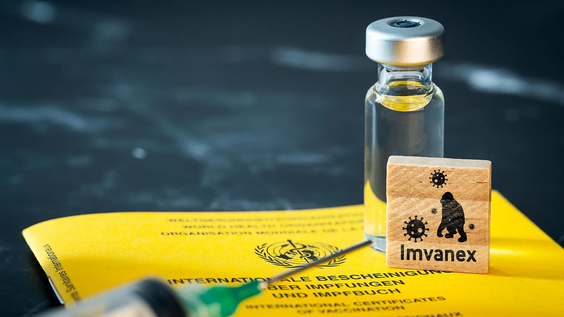27 May 2022: WHO World Health Organization vaccination certificate a syringe and a wooden cube labeled IMVANEX, smallpox vaccine, Imvanex as a vaccine for monkeypox virus PHOTOMONTAGE *** Impfpass der WHO Weltgesundheitsorganisation eine Spritze und einem Holzwürfel mit Aufschrift IMVANEX, Pocken Impfstoff, Imvanex als Impfung für das Affenpocken Virus FOTOMONTAGE