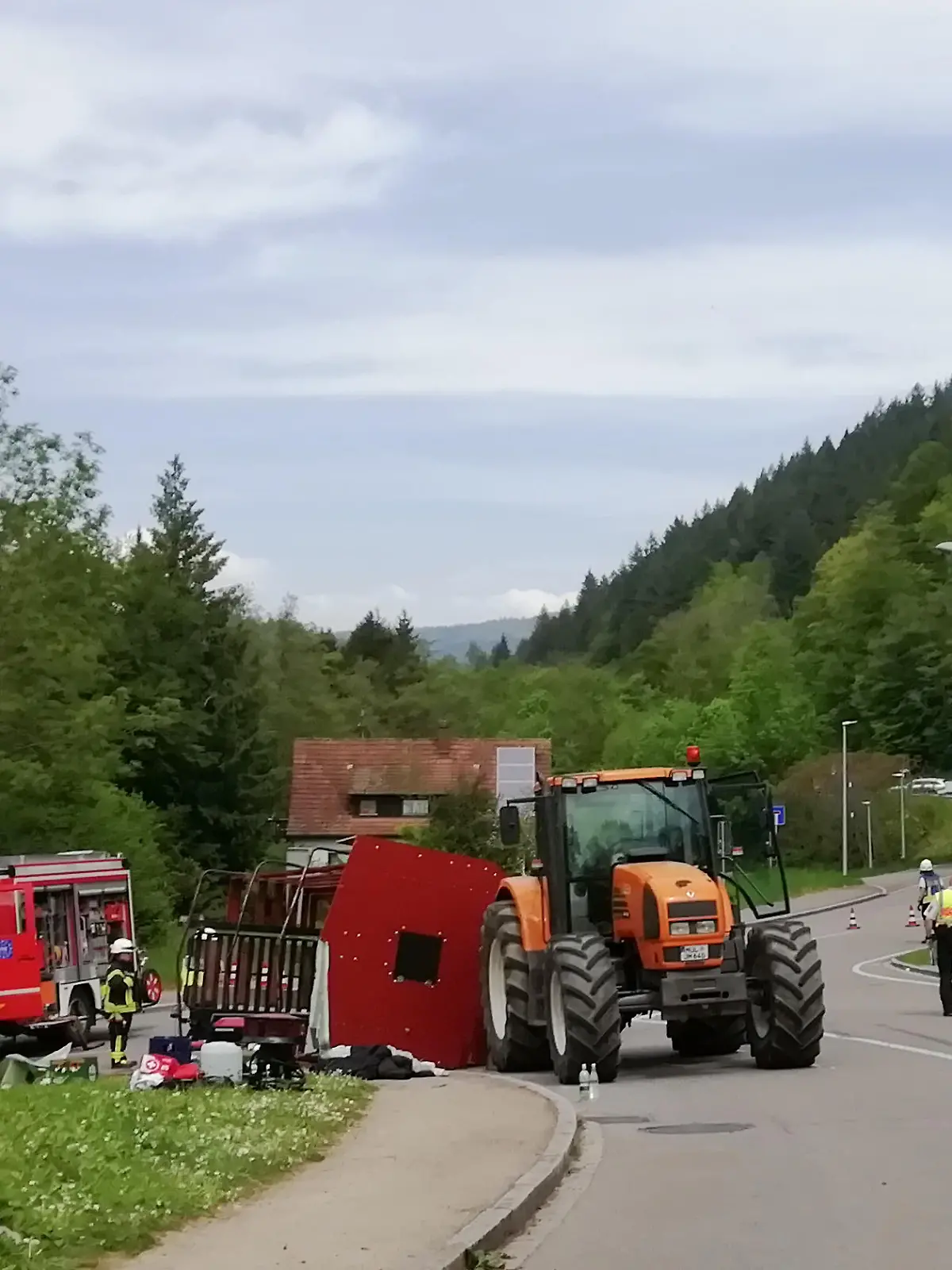 Rettungskräfte stehen nach einem Unfall neben einem einem umgestürzten Maiwagen. Bei dem Unfall mit einem Maiwagen-Anhänger sind im südbadischen Kandern rund dreißig Menschen verletzt worden. Zehn Menschen hätten schwere Verletzungen erlitten, teilte die Polizei am Mittwoch mit.
