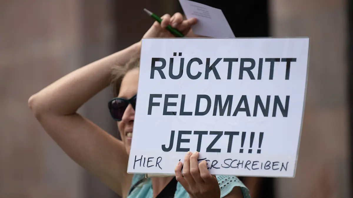 09.06.2022, Hessen, Frankfurt/Main: ·Rücktritt Feldmann jetzt· steht auf dem Plakat einer Frau, die sich vor dem Römer an Passanten wendet. Feldmann (SPD), Oberbürgermeister von Frankfurt, steht unter anderem wegen Korruptionsvorwürfen unter Druck und sieht sich massiven Rücktrittsforderungen ausgesetzt. Auch die eigene Fraktion fordert seinen Rücktritt. Foto: Boris Roessler/dpa +++ dpa-Bildfunk +++