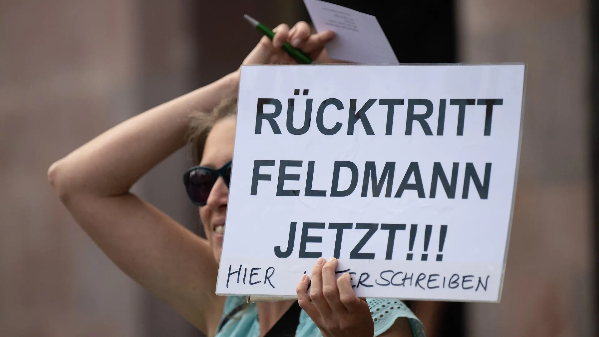 09.06.2022, Hessen, Frankfurt/Main: ·Rücktritt Feldmann jetzt· steht auf dem Plakat einer Frau, die sich vor dem Römer an Passanten wendet. Feldmann (SPD), Oberbürgermeister von Frankfurt, steht unter anderem wegen Korruptionsvorwürfen unter Druck und sieht sich massiven Rücktrittsforderungen ausgesetzt. Auch die eigene Fraktion fordert seinen Rücktritt. Foto: Boris Roessler/dpa +++ dpa-Bildfunk +++