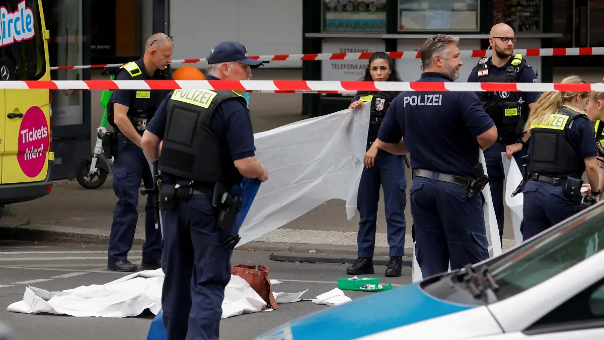 Police officers work next to the body of a victim at the scene where a car crashed into a group of people near Breitscheidplatz in Berlin, Germany, June 8, 2022. REUTERS/Michele Tantussi