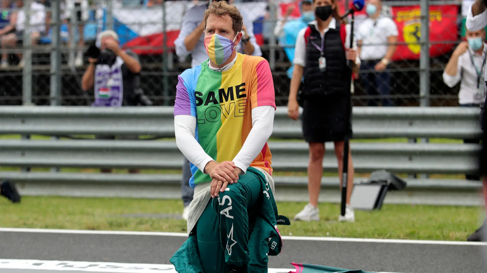 ARCHIV - 01.08.2021, Ungarn, Mogyorod: Motorsport: Formel-1-Weltmeisterschaft, Großer Preis von Ungarn, Rennen: Sebastian Vettel aus Deutschland vom Team Aston-Martin kniet vor dem Rennen auf der Rennstrecke zur Unterstützung der Black-Lives-Matter-Bewegung nieder und trägt eine T-Shirt in Regenbogenfarben. (zu dpa ««Heuchler» Vettel: Vom Weltmeister zum Weltverbesserer») Foto: Florion Goga/Pool Reuters/AP/dpa +++ dpa-Bildfunk +++