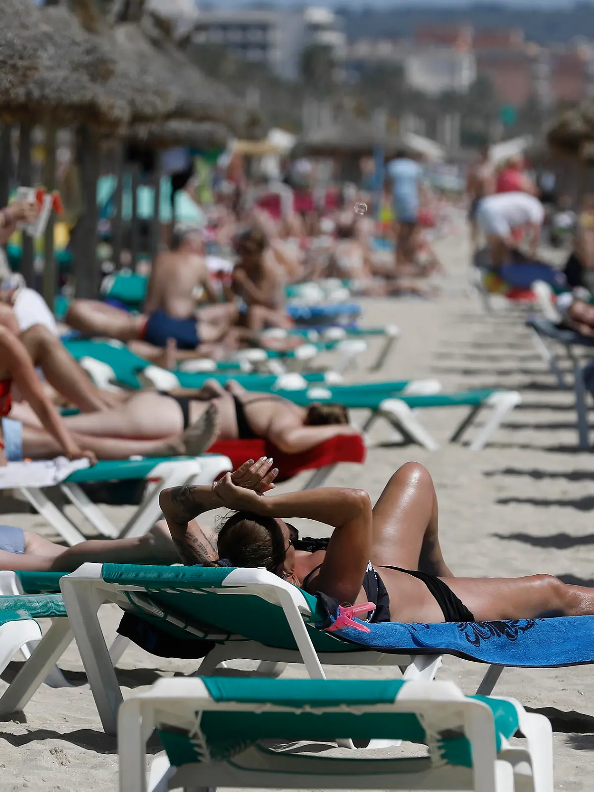 Menschen sonnen sich am Strand von Arenal.