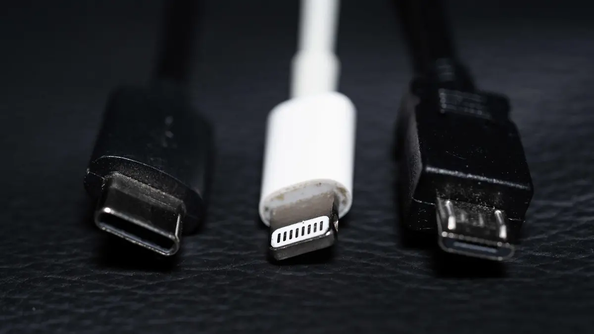 ARCHIV - 22.09.2021, Niedersachsen, Oldenburg: Ein USB-C (l-r), ein Apple Lightning und ein Micro-USB Kabel (l-r) liegen nebeneinander zu sehen. (zu dpa "Einigung auf einheitliche Ladekabel in der EU möglich") Foto: Mohssen Assanimoghaddam/dpa +++ dpa-Bildfunk +++