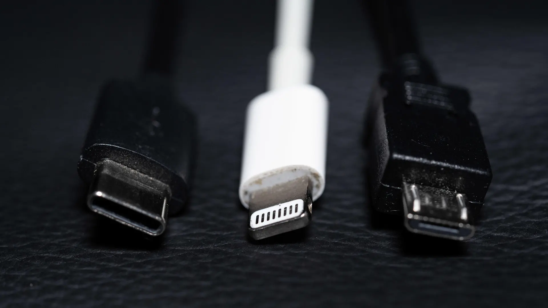 ARCHIV - 22.09.2021, Niedersachsen, Oldenburg: Ein USB-C (l-r), ein Apple Lightning und ein Micro-USB Kabel (l-r) liegen nebeneinander zu sehen. (zu dpa "Einigung auf einheitliche Ladekabel in der EU möglich") Foto: Mohssen Assanimoghaddam/dpa +++ dpa-Bildfunk +++