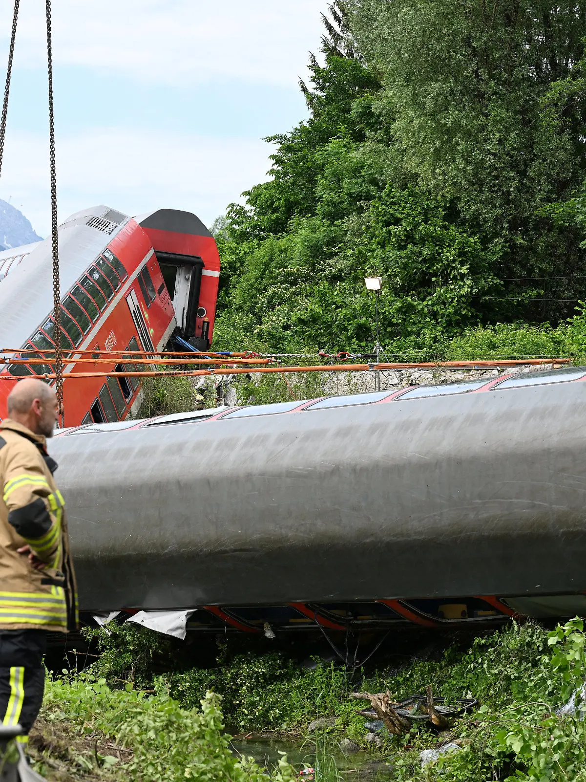 04.06.2022, Bayern, Garmisch-Partenkirchen: Auch am zweiten Tag sind zahlreiche Einsatz- und Rettungskräfte nach einem schweren Zugunglück im Einsatz. Bei dem Unglück sind mindestens vier Menschen ums Leben gekommen. Ein Regionalexpress entgleiste in der beliebten oberbayerischen Urlaubsregion auf dem Weg von Garmisch nach München. Foto: Angelika Warmuth/dpa +++ dpa-Bildfunk +++