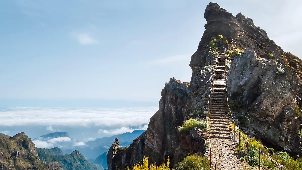 "Stairs to heaven" - Breathtaking view at famous mountain footpath from Pico do Arieiro to Pico Ruivo on the Portuguese Madeira island. Trekking Around the world traveling with kids concept image.
