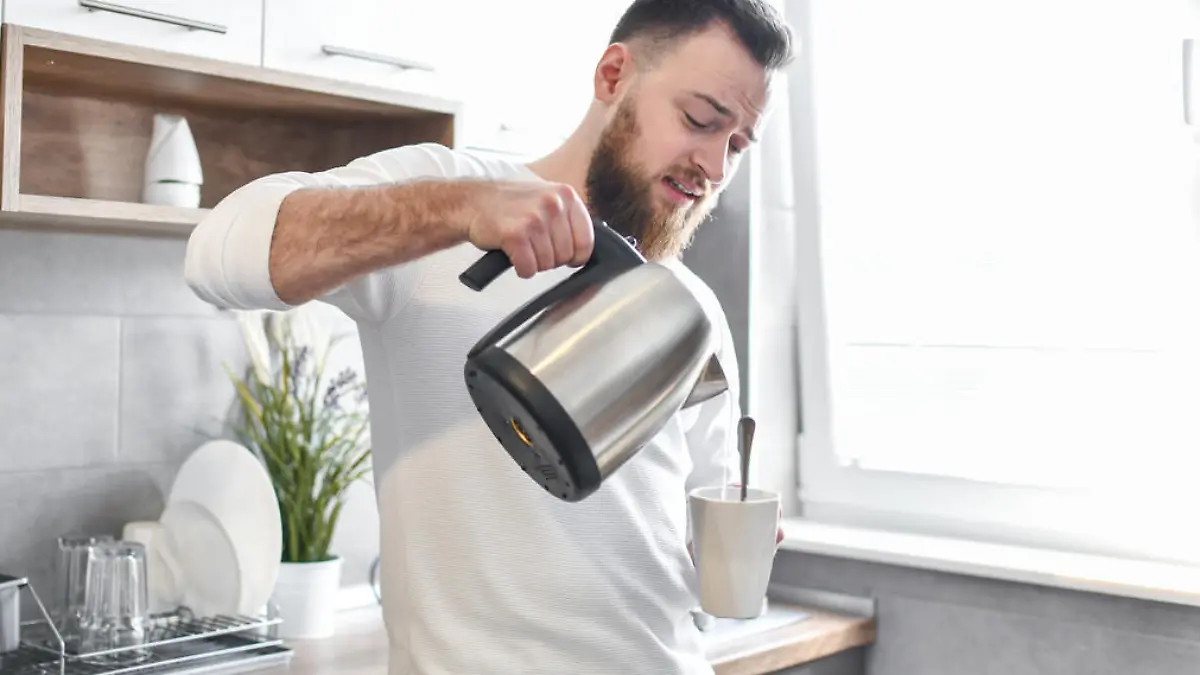 Handsome Male Pouring Himself Coffee In Kitchen