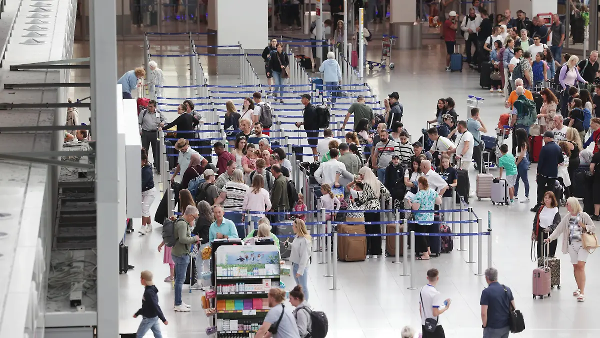 13.07.2023, Nordrhein-Westfalen, Düsseldorf: Fluggäste stehen in Warteschlangen im Terminal des Flughafens DUS nachdem sich Aktivisten der Gruppe Letzte Generation auf dem Flugfeld festgeklebt haben. Foto: David Young/dpa +++ dpa-Bildfunk +++