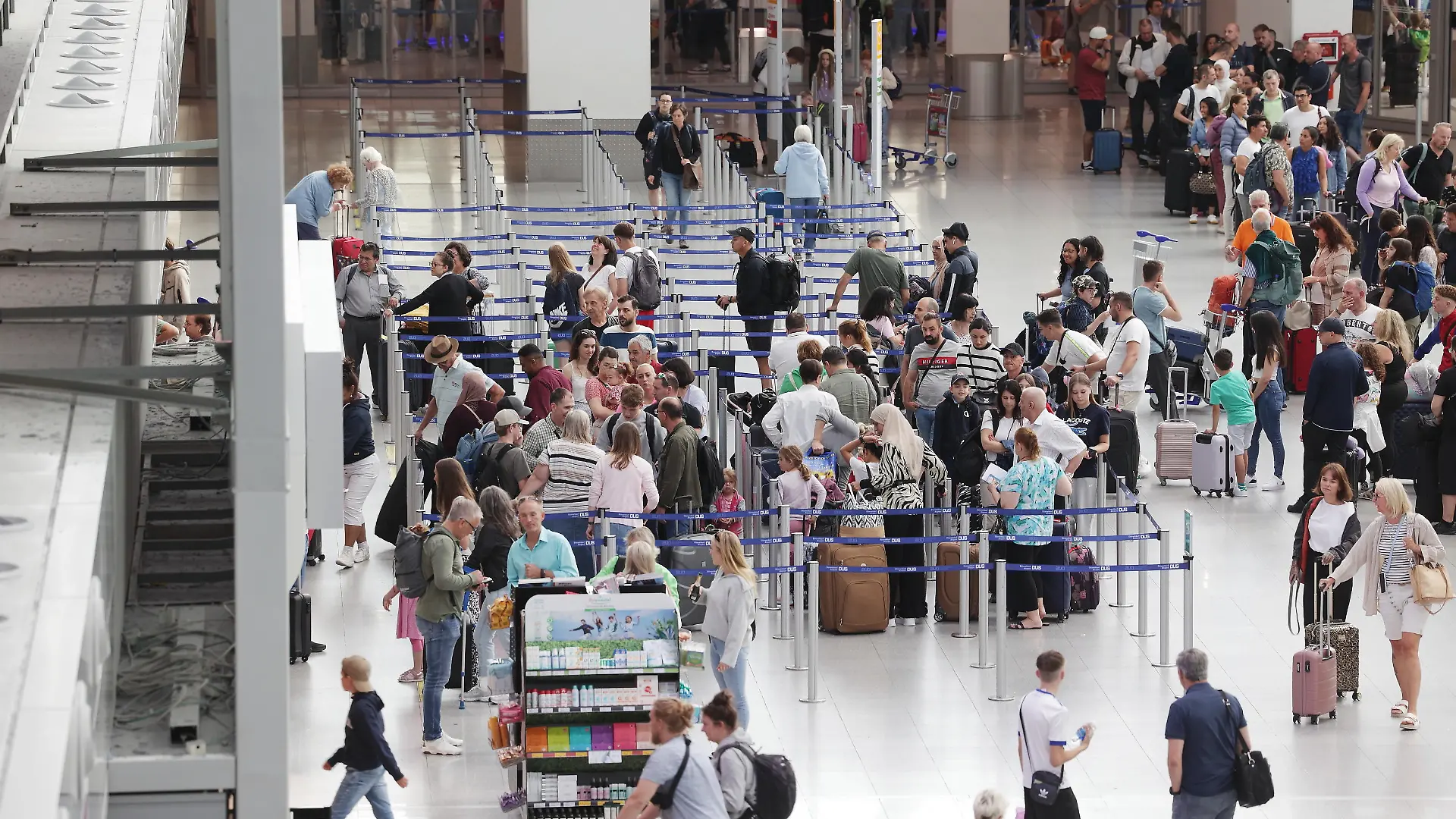 13.07.2023, Nordrhein-Westfalen, Düsseldorf: Fluggäste stehen in Warteschlangen im Terminal des Flughafens DUS nachdem sich Aktivisten der Gruppe Letzte Generation auf dem Flugfeld festgeklebt haben. Foto: David Young/dpa +++ dpa-Bildfunk +++