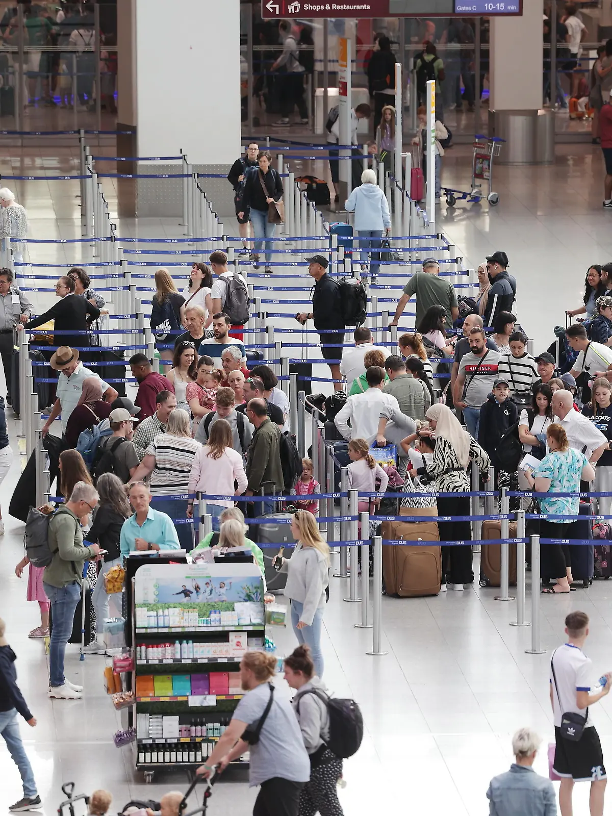13.07.2023, Nordrhein-Westfalen, Düsseldorf: Fluggäste stehen in Warteschlangen im Terminal des Flughafens DUS nachdem sich Aktivisten der Gruppe Letzte Generation auf dem Flugfeld festgeklebt haben. Foto: David Young/dpa +++ dpa-Bildfunk +++