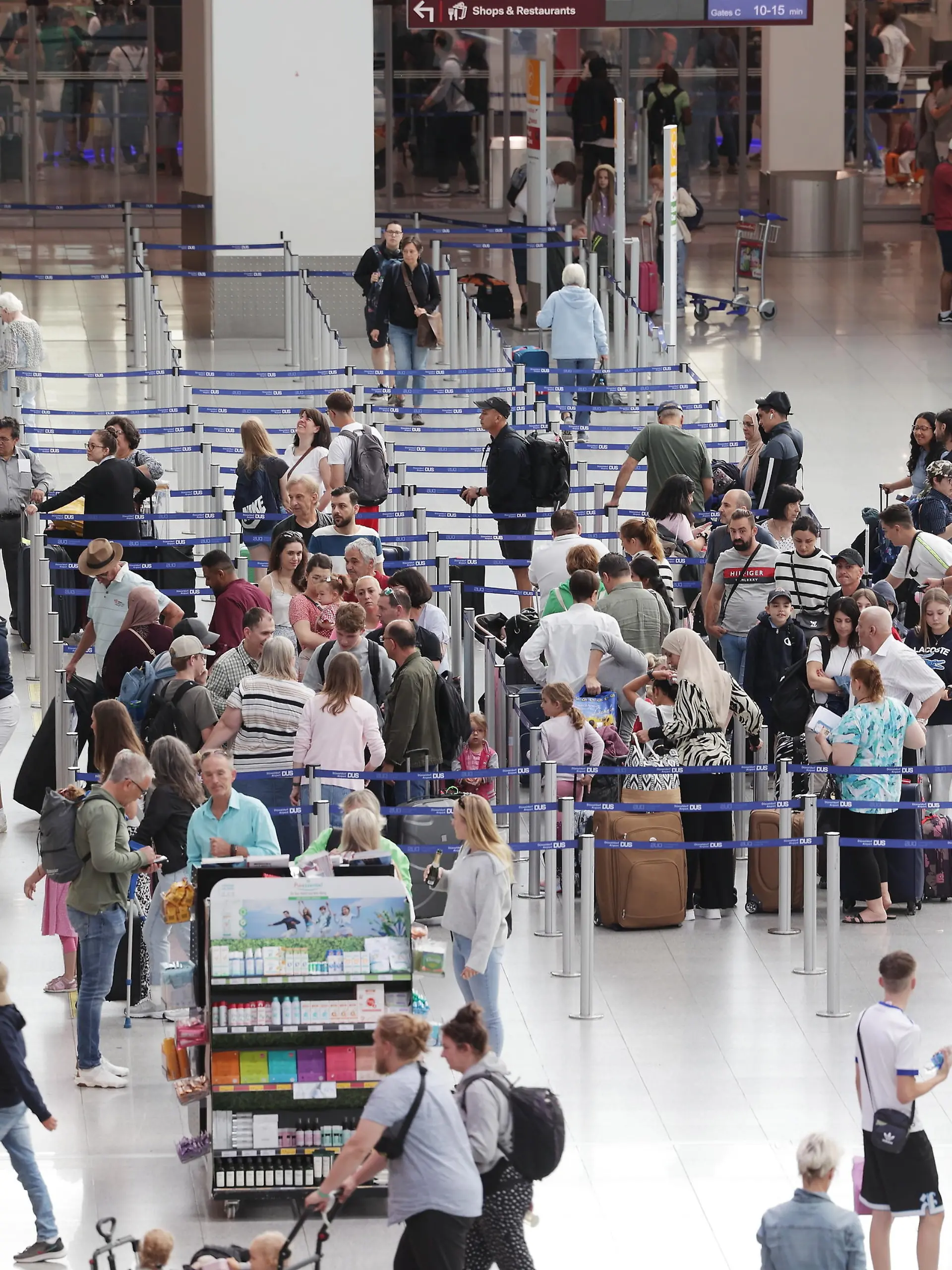 13.07.2023, Nordrhein-Westfalen, Düsseldorf: Fluggäste stehen in Warteschlangen im Terminal des Flughafens DUS nachdem sich Aktivisten der Gruppe Letzte Generation auf dem Flugfeld festgeklebt haben. Foto: David Young/dpa +++ dpa-Bildfunk +++