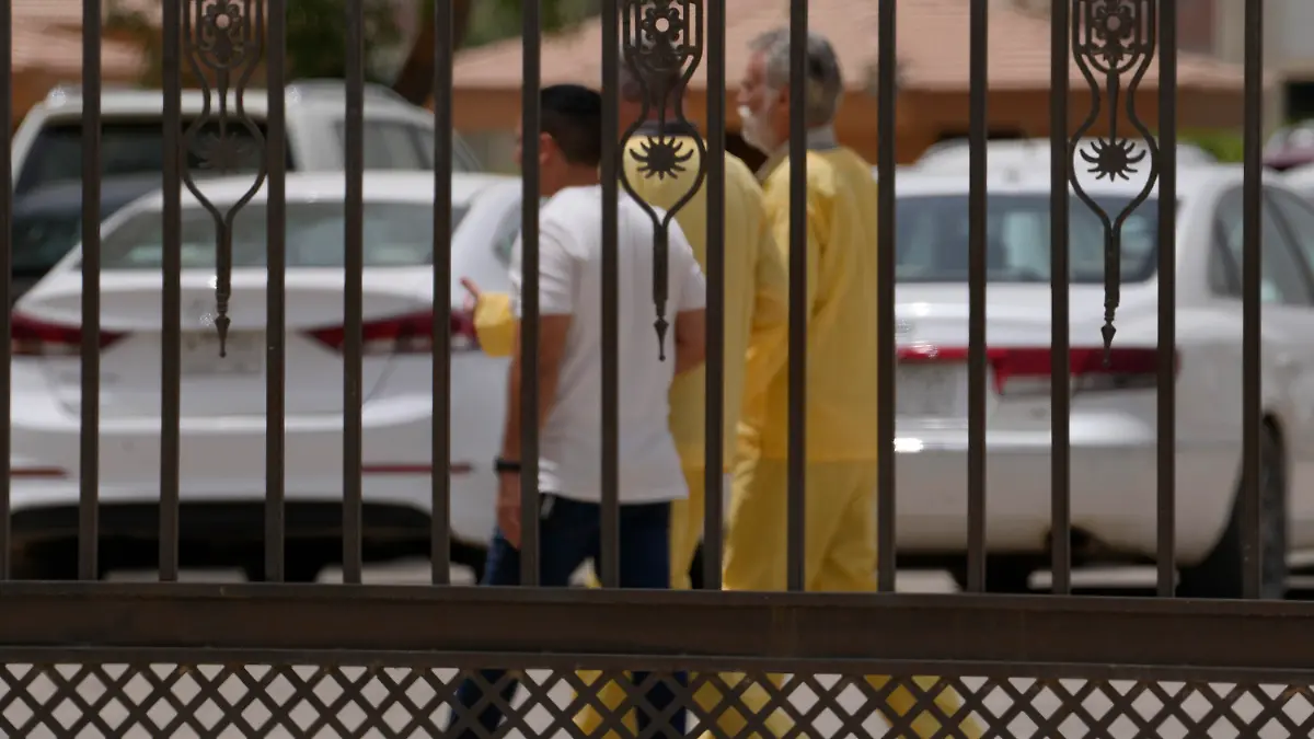 Jim Fitton, center right and Volker Waldmann center left, are handcuffed as they walk outside a courtroom in Baghdad, Iraq, Sunday, May 15, 2022. Fitton from Britain and Waldmann a German, who are accused of smuggling ancient relics out of Iraq, had a tense day in court on Sunday as both pleaded their innocence to judges who questioned their intention and the size of items taken. (AP Photo/Hadi Mizban)