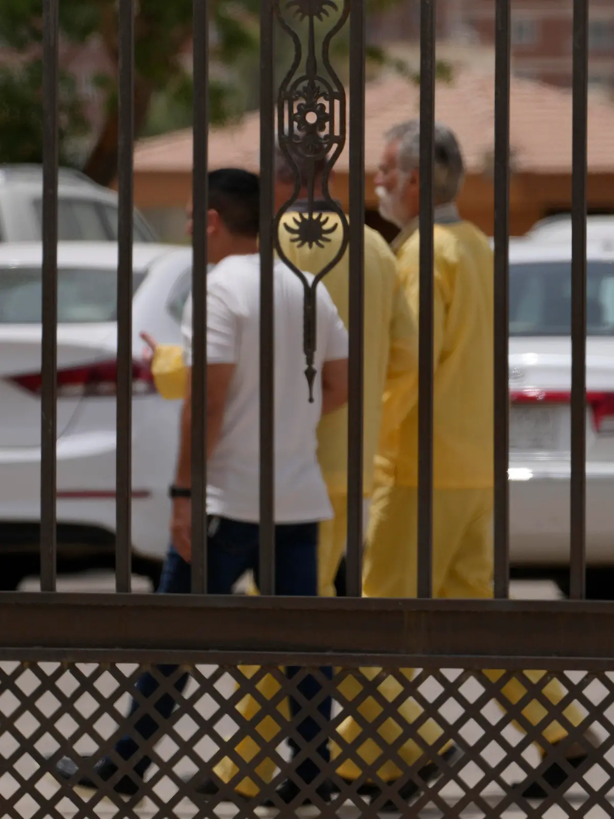 Jim Fitton, center right and Volker Waldmann center left, are handcuffed as they walk outside a courtroom in Baghdad, Iraq, Sunday, May 15, 2022. Fitton from Britain and Waldmann a German, who are accused of smuggling ancient relics out of Iraq, had a tense day in court on Sunday as both pleaded their innocence to judges who questioned their intention and the size of items taken. (AP Photo/Hadi Mizban)