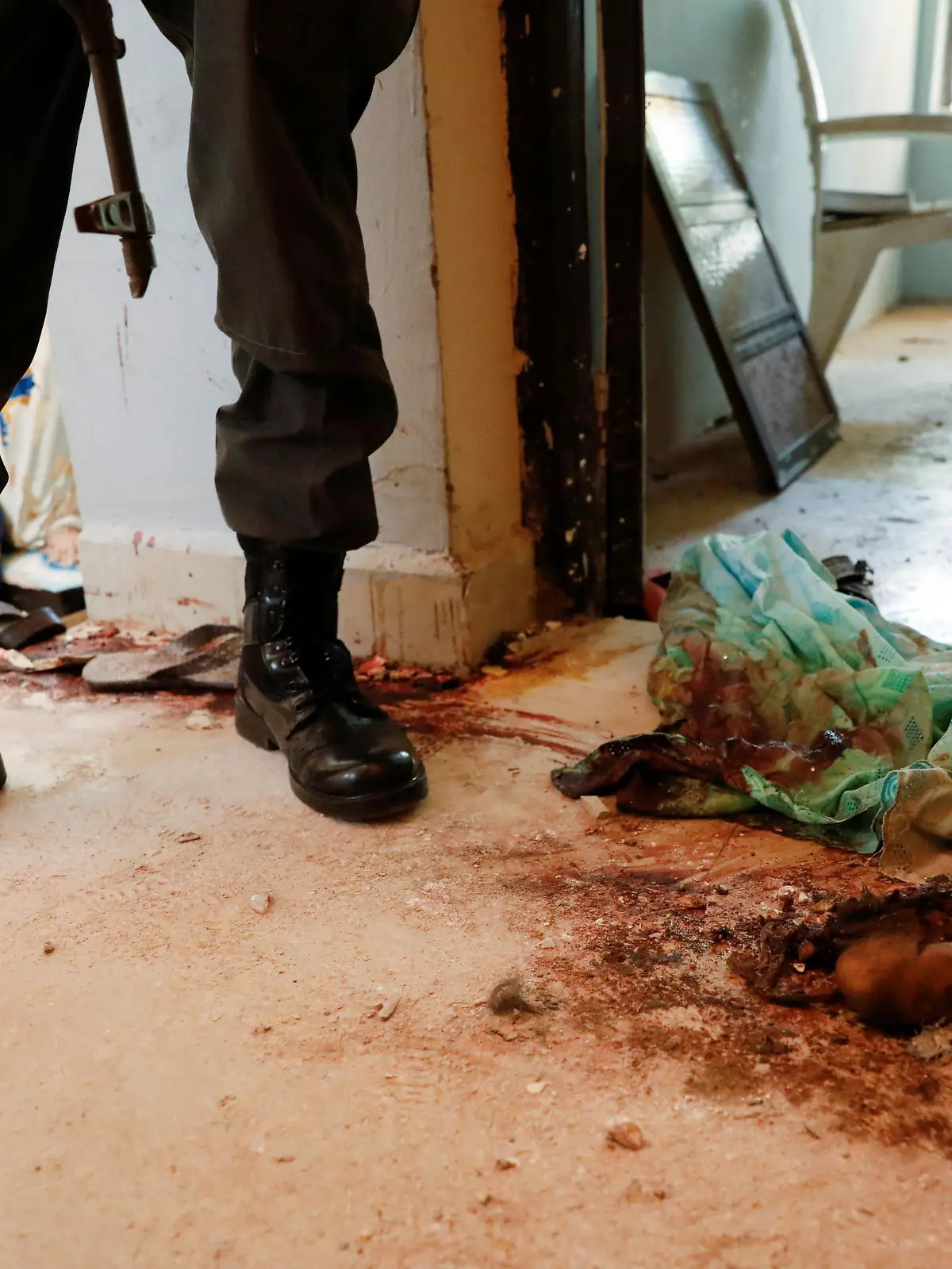 A policeman stands next to blood stains and littered items, following an attack by gunmen on worshippers during a Sunday service mass at St. Francis Catholic Church in Owo, Ondo, Nigeria, June 6, 2022. REUTERS/Temilade Adelaja