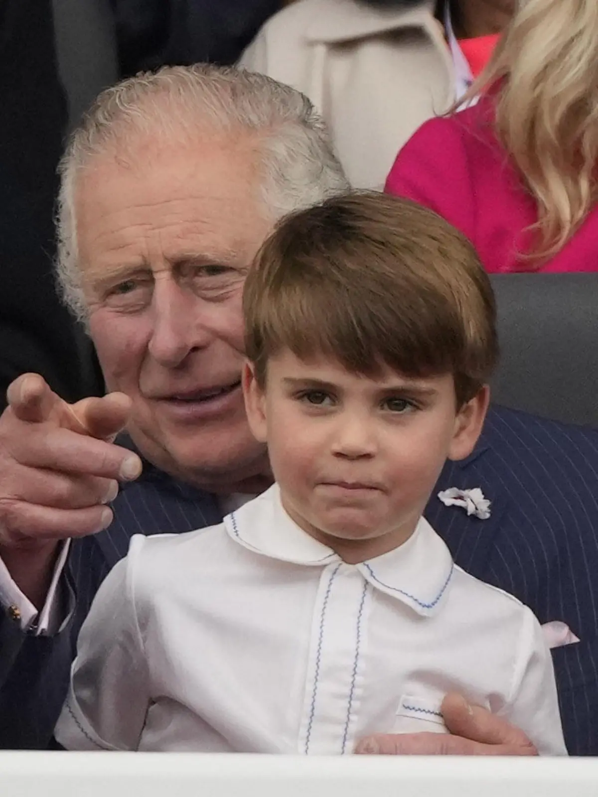 05.06.2022, Großbritannien, London: Prinz Louis sitzt auf dem Schoß seines Großvaters Charles, Prinz von Wales, während des Festumzuges vor dem Buckingham Palace am vierten Tag der Feierlichkeiten zum Platinjubiläum der Queen. Der Festumzug ist ein Karnevalsumzug auf der Mall mit riesigen Puppen und Prominenten, die Schlüsselmomente aus den sieben Jahrzehnten der Thronbesteigung von Königin Elizabeth II. darstellen. Foto: Frank Augstein/PA Wire/dpa +++ dpa-Bildfunk +++
