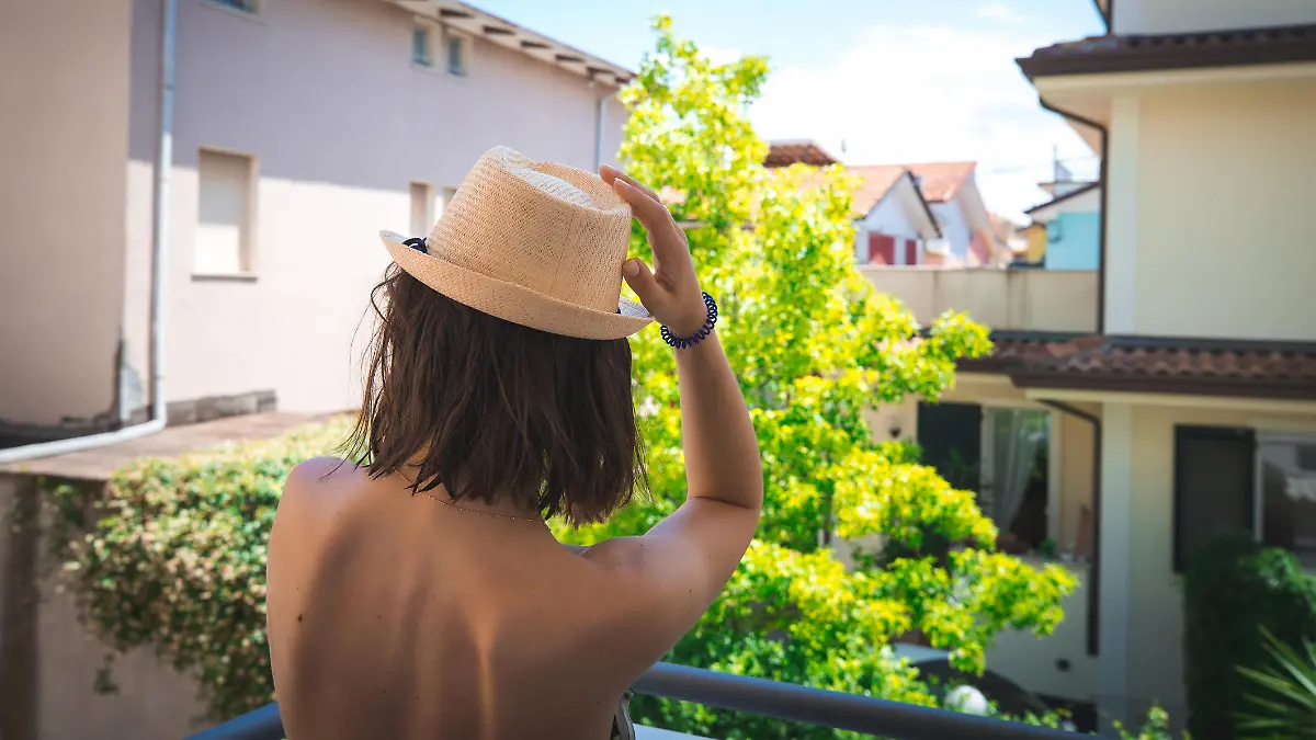 Girl with naked back on italian houses background. Vacation concept.