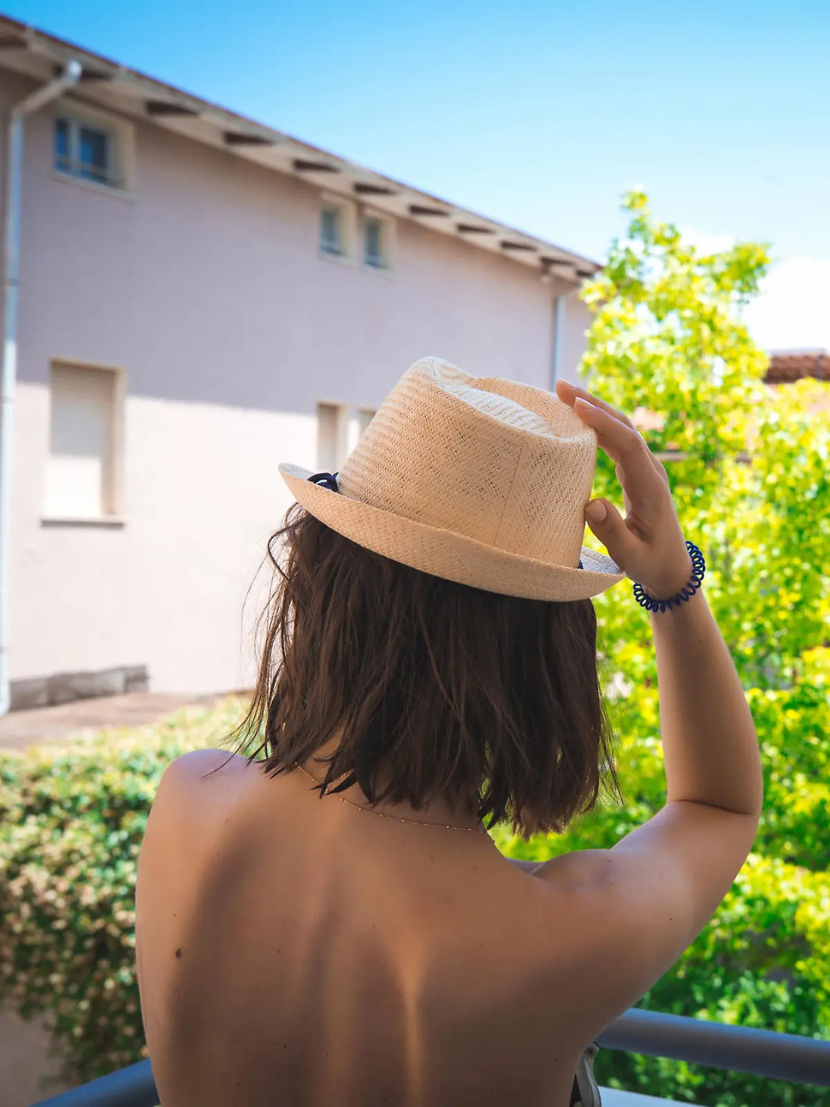 Girl with naked back on italian houses background. Vacation concept.