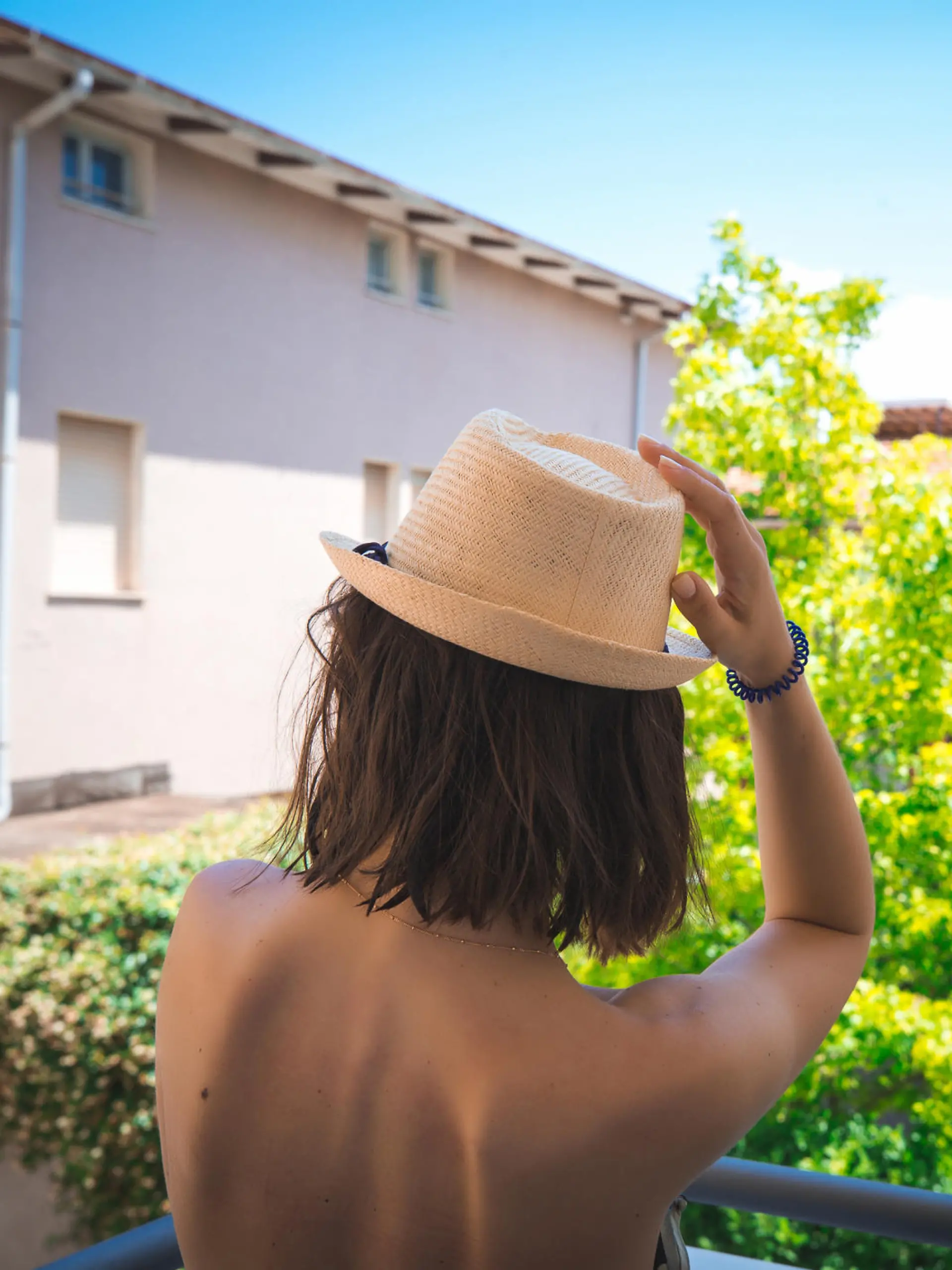 Girl with naked back on italian houses background. Vacation concept.